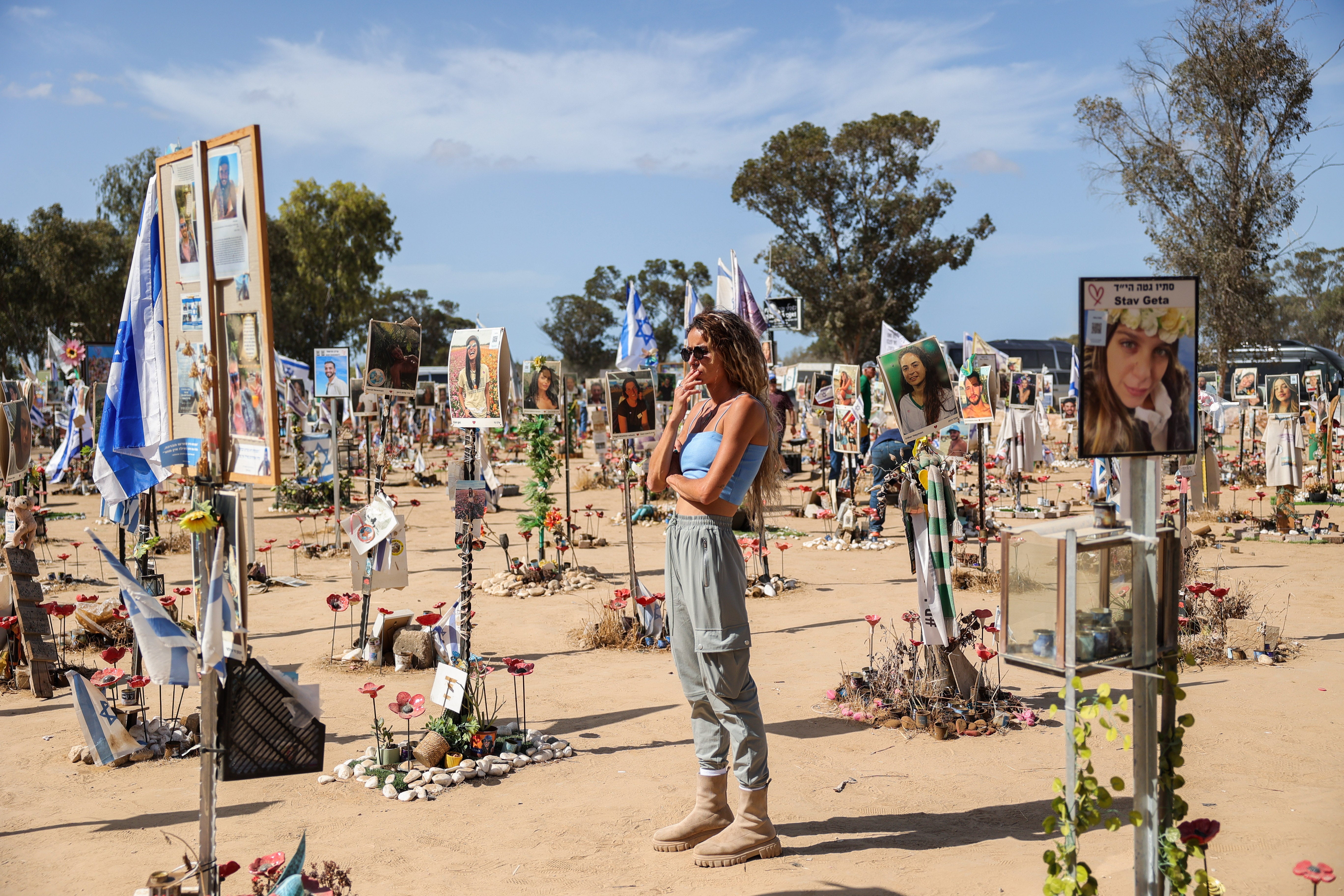 A woman looks at pictures and memorials for Israeli festival goers who killed by Hamas at the site of the Supernova Music Festival rave near Kibbutz Reim, Southern Israel, 19 September 2024.