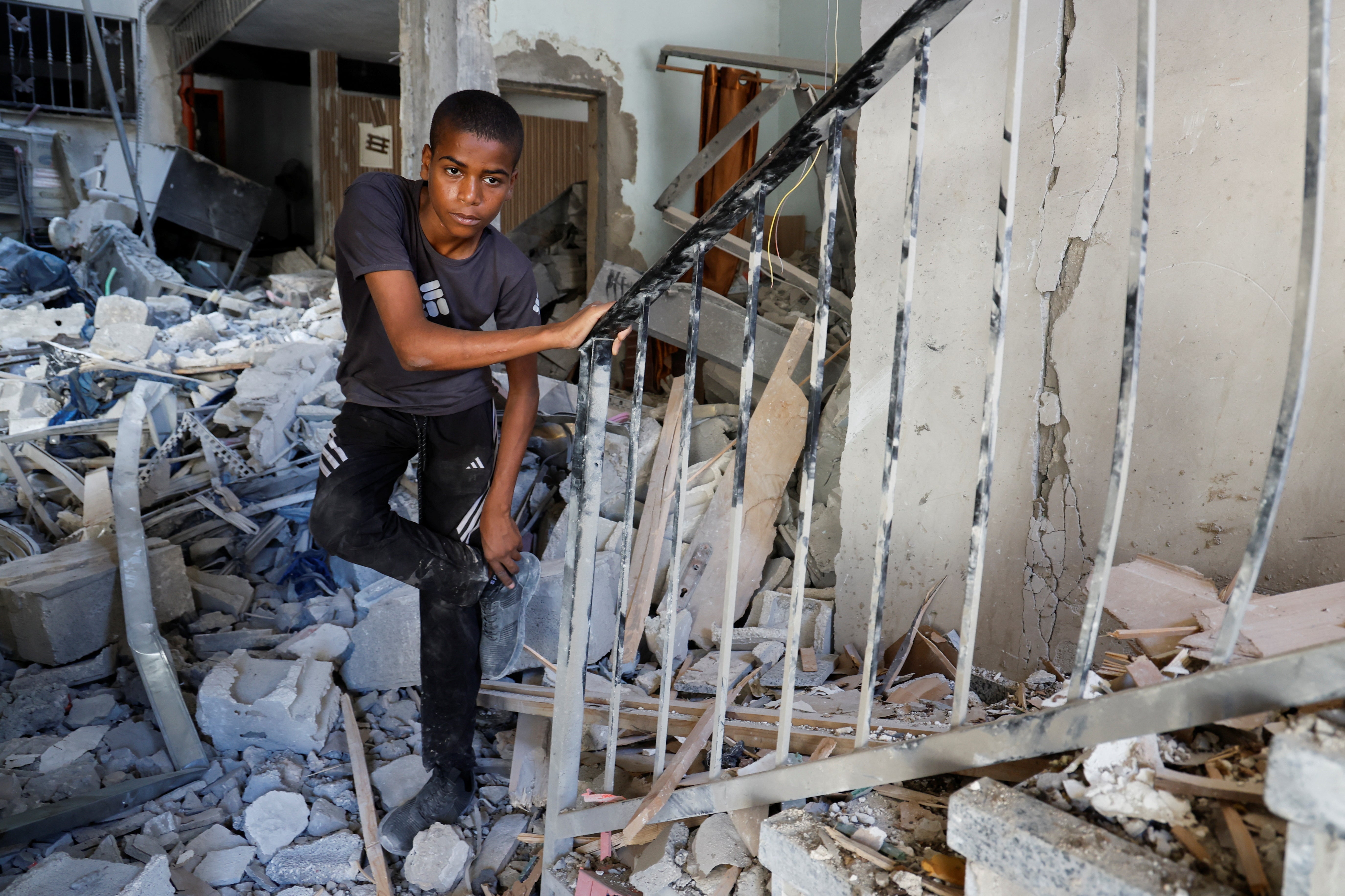 A Palestinian boy stands amidst the rubble at the site of an Israeli air strike in Tulkarm camp, in Tulkarm, in the Israeli-occupied West Bank on Friday