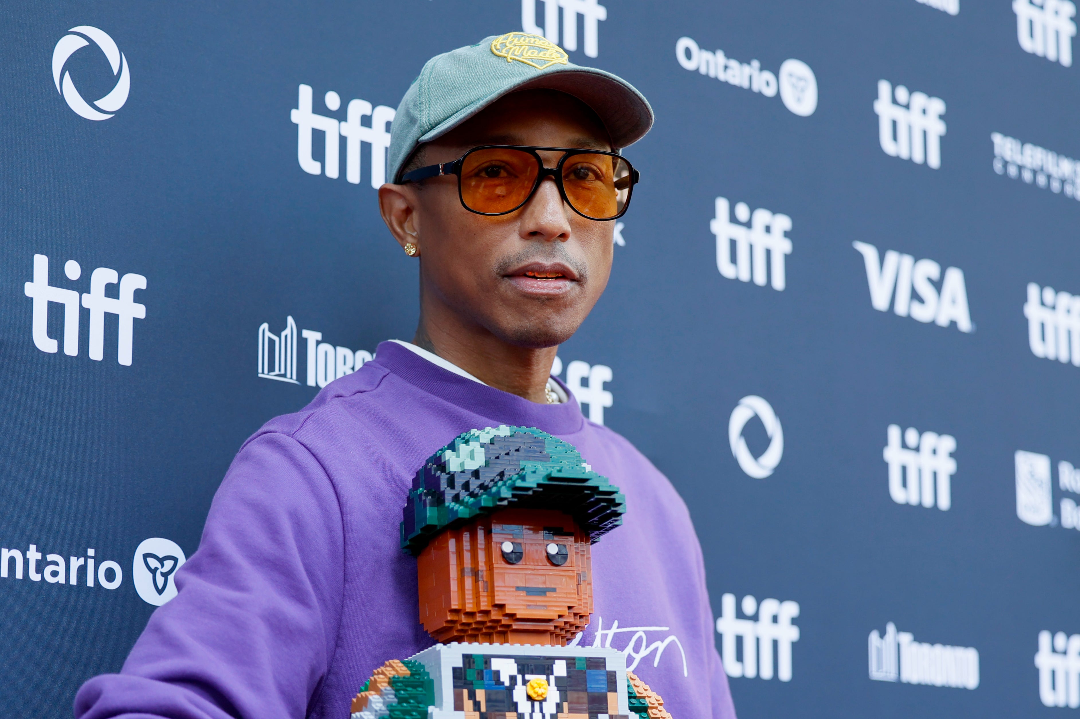 Pharrell Williams poses with a Lego likeness of himself at Toronto International Film Festival