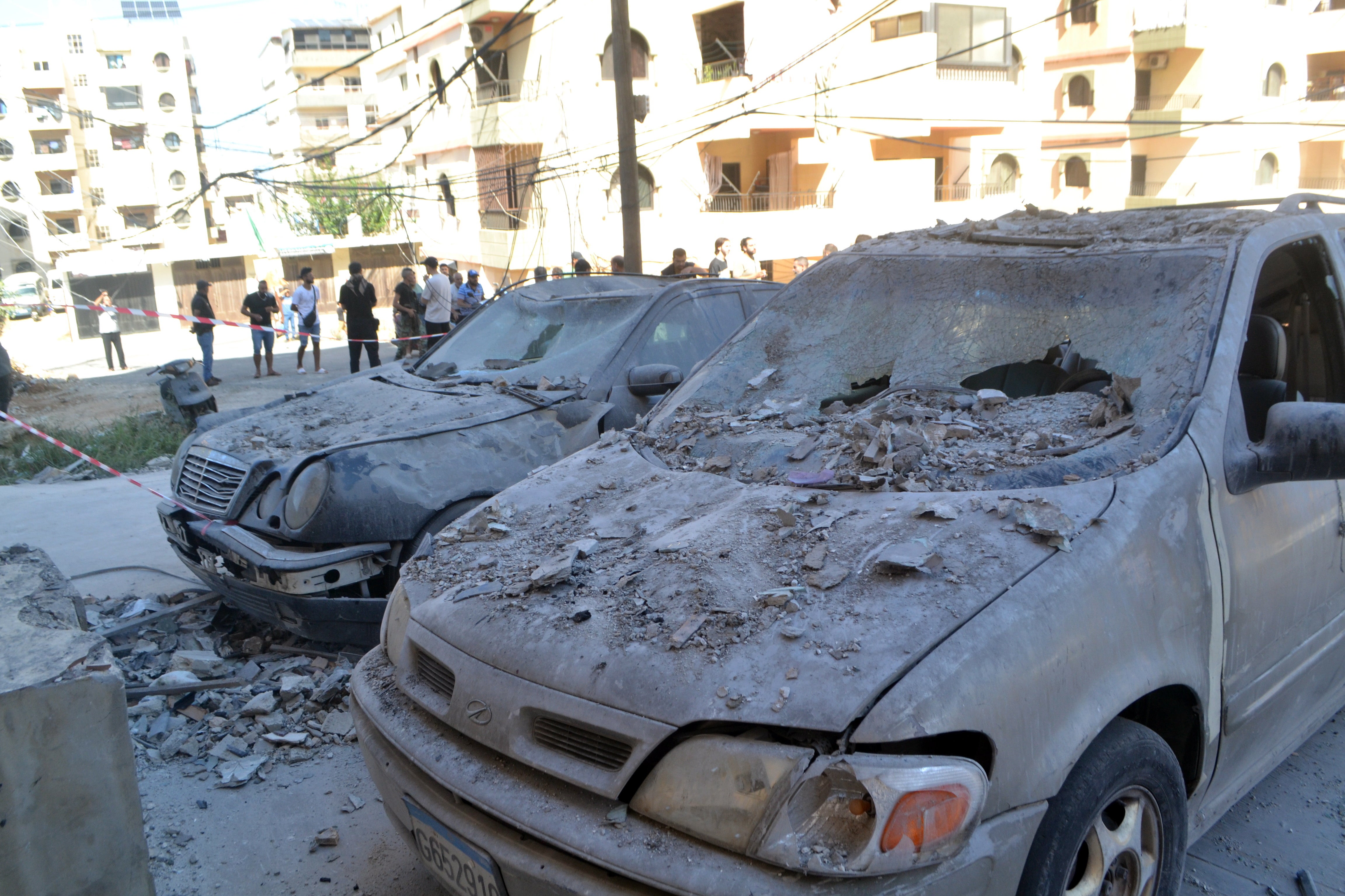 Damaged cars at the site where an apartment building was targeted by an Israeli military strike in the Palestinian refugee camp of Al-Baddawi in Tripoli