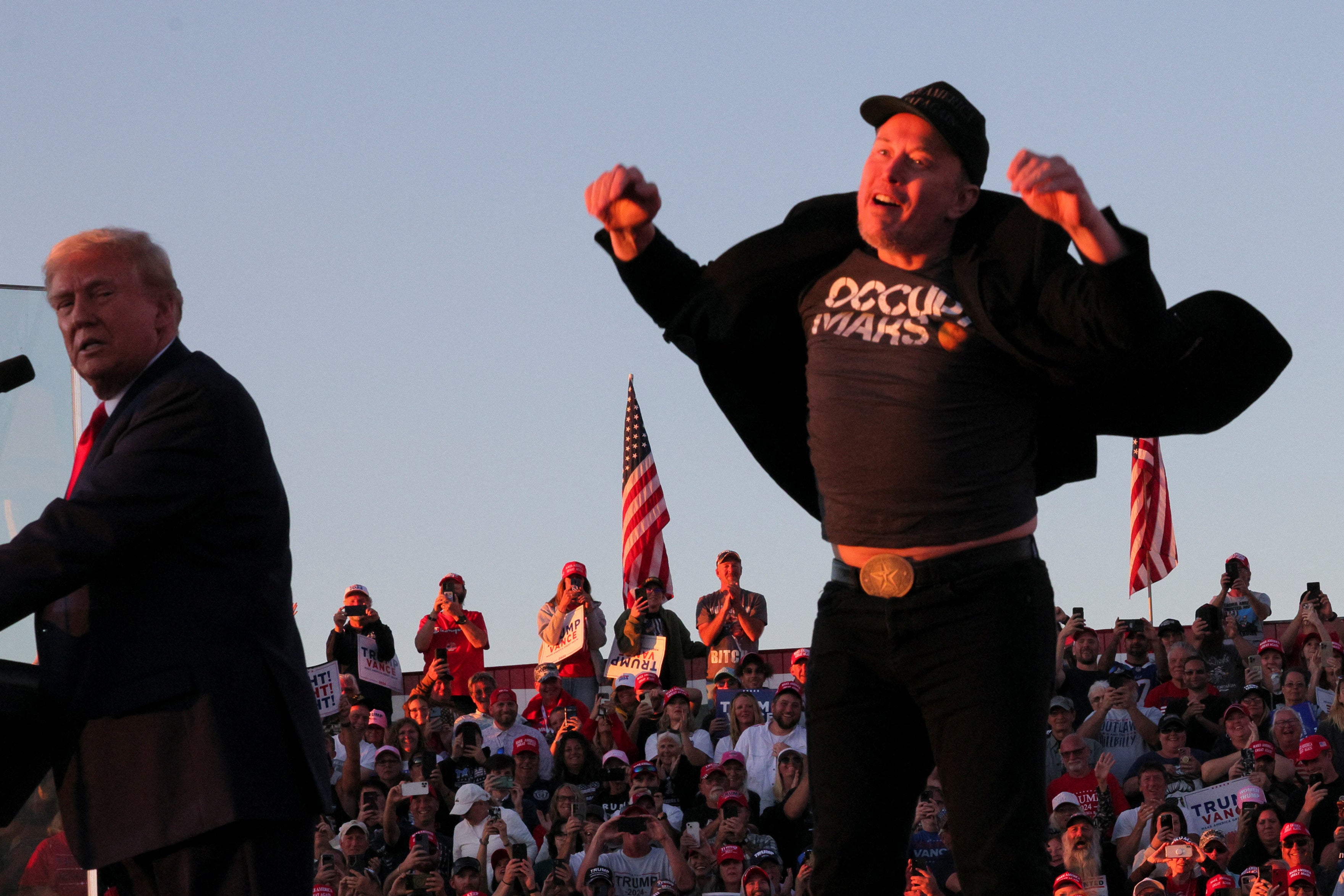 Tesla CEO and X owner Elon Musk reacts next to Republican presidential nominee and former U.S. president Donald Trump during a campaign rally, at the site of the July assassination attempt against Trump, in Butler, Pennsylvania, U.S., October 5, 2024. REUTERS/Brian Snyder