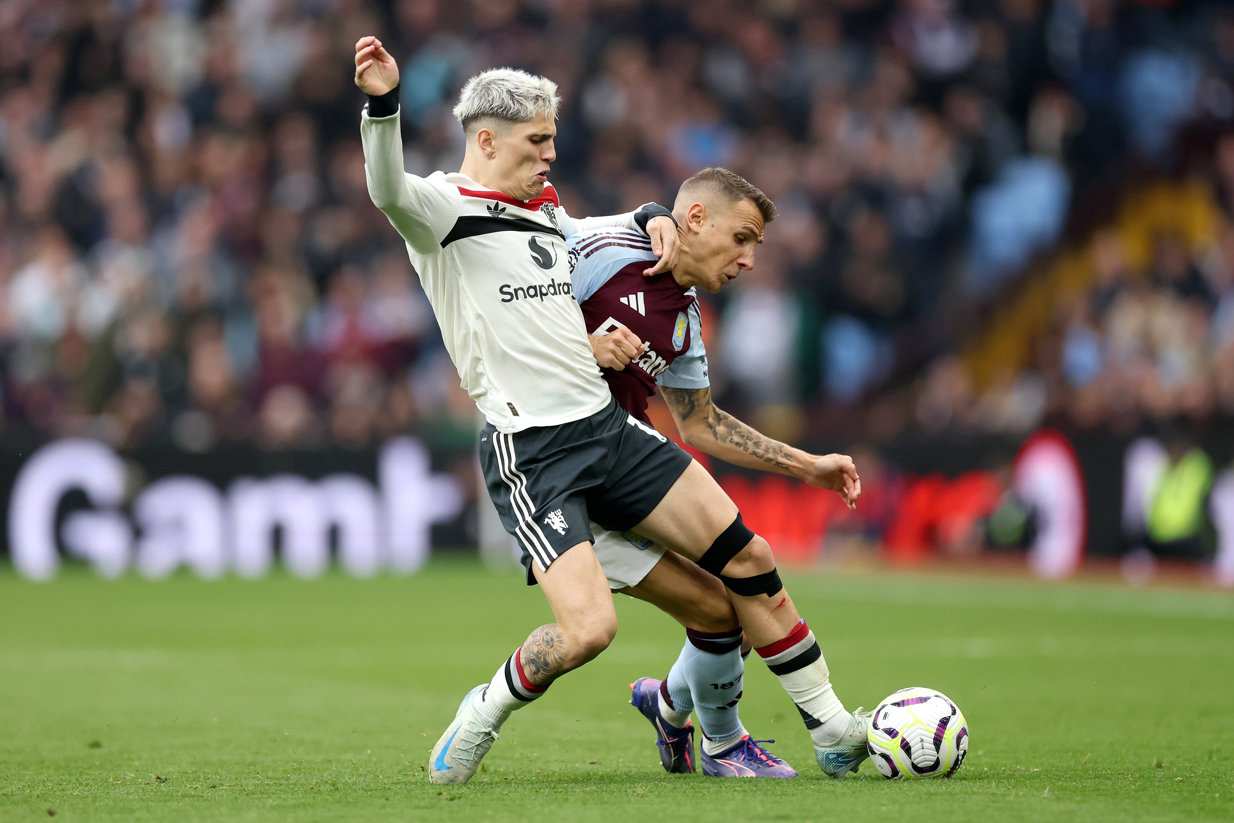 Alejandro Garnacho is challenged by Lucas Digne