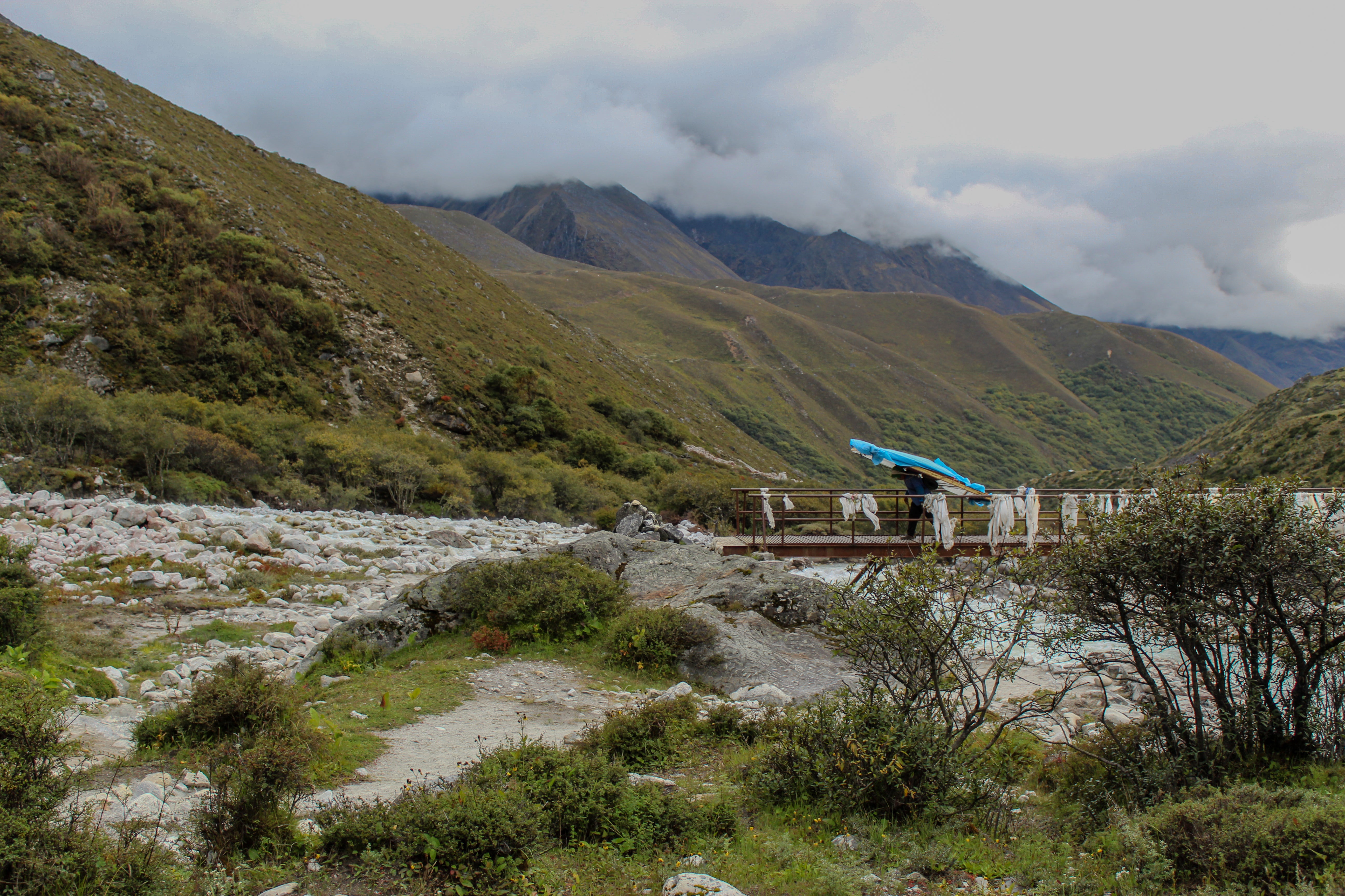 A Nepali porter carrying a door across a bridge in the Khumbu Valley