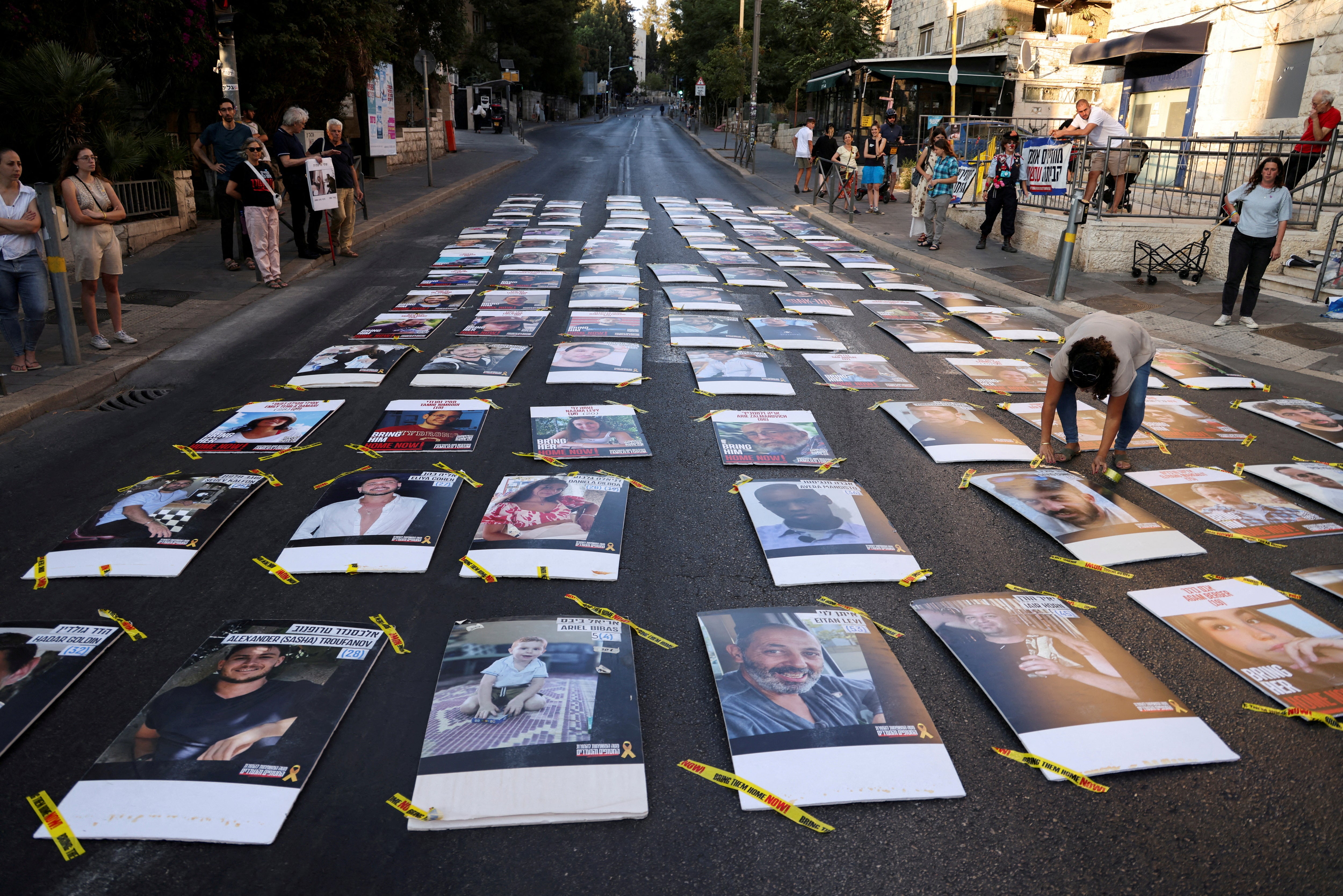 Family members and supporters of hostages who were kidnapped during the deadly October 7 attack, place 107 pictures of hostages outside Israeli Prime Minister Benjamin Netanyahu's residence