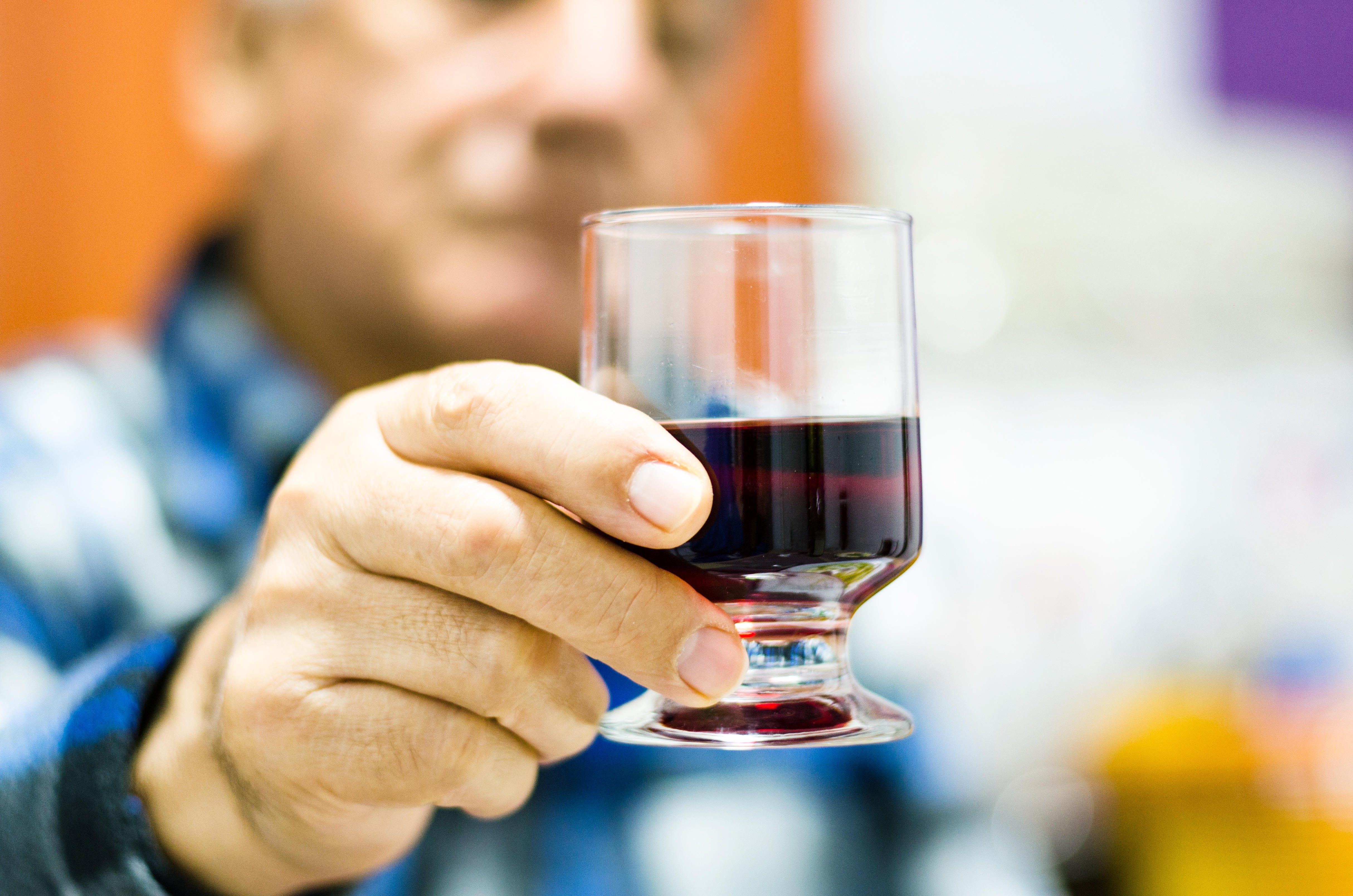 A Middle aged man holding a glass of red wine