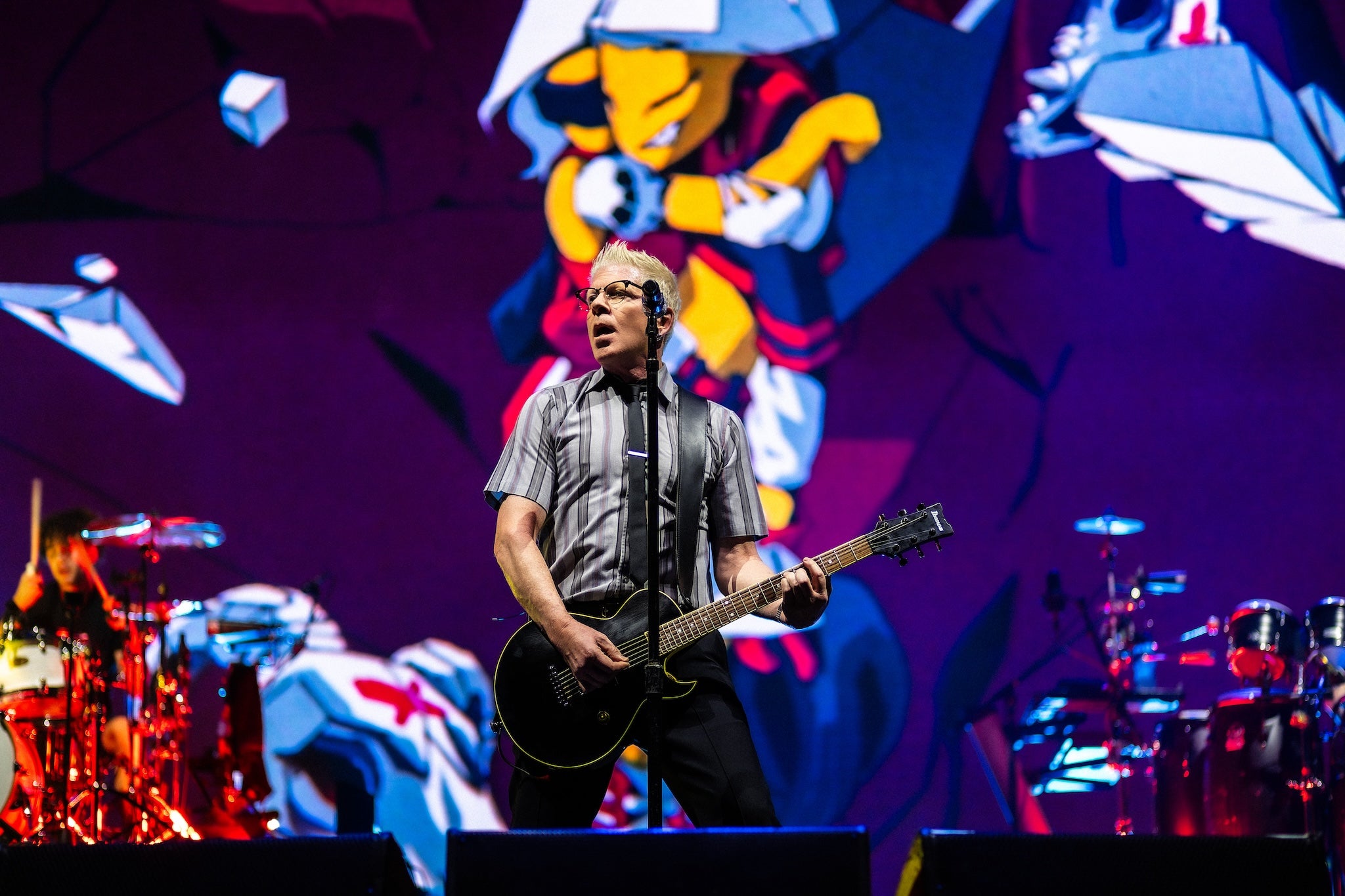 Still sporting the bleach-heavy spiked-up hair of his youth, Dexter Holland of The Offspring pictured on stage