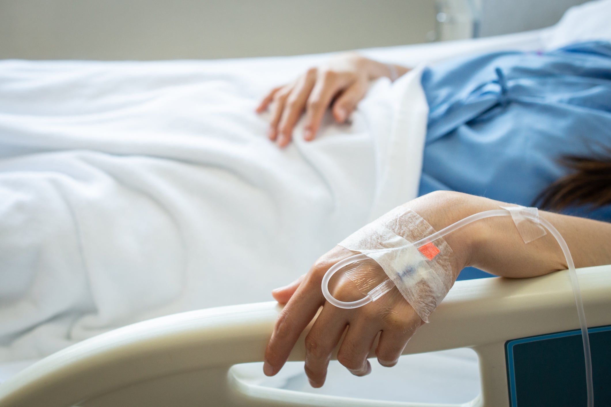 A woman rests in a hospital, receiving intravenous fluid a vein in her hand. Amid a nationwide shortage of the fluid following damage to a plant in North Carolina during Hurricane Helene, hospitals across the country are taking action to deal with the shortage