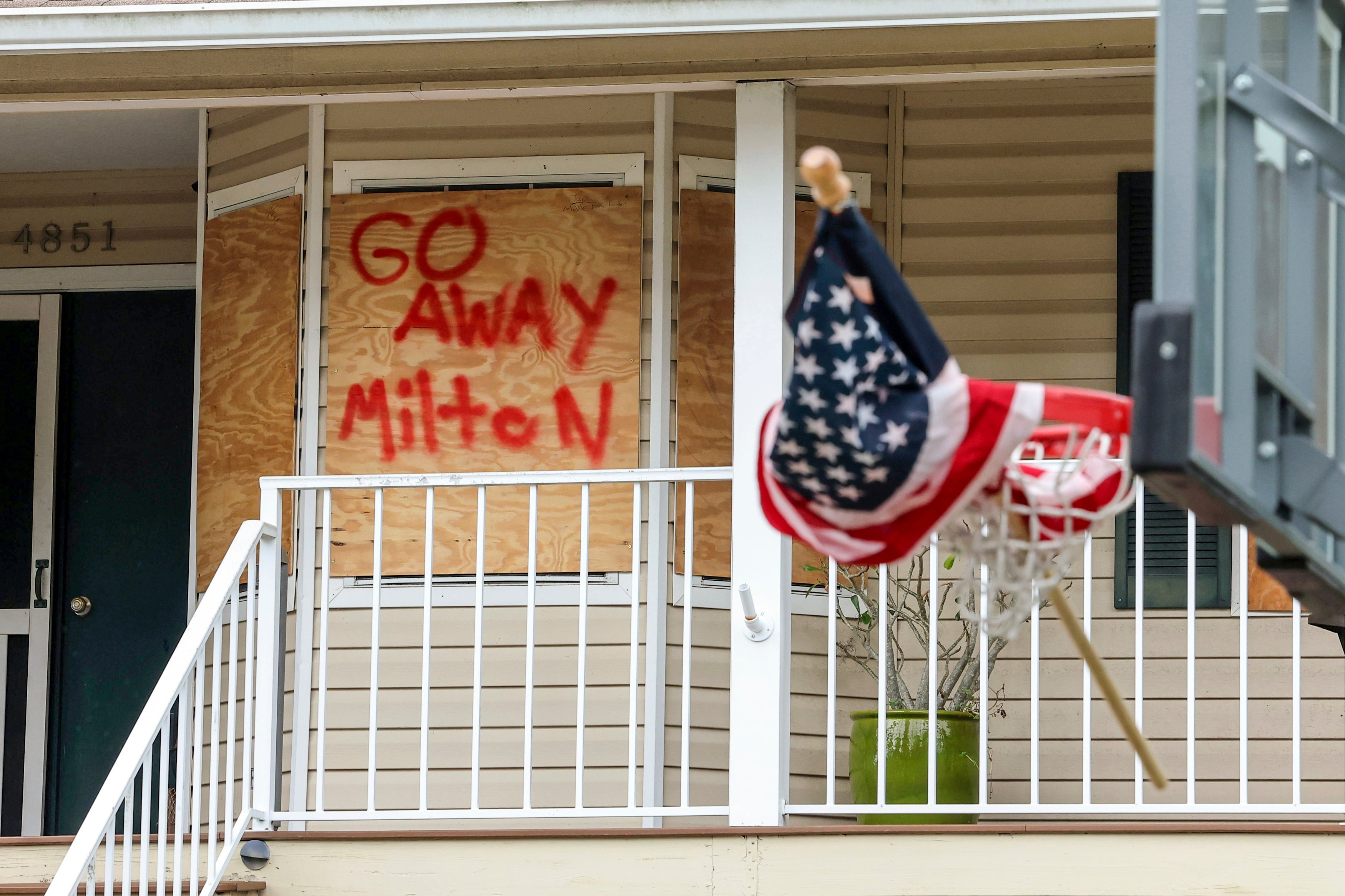 Family boards up home in preparation for Hurricane Milton on Monday in Port Richey, Florida