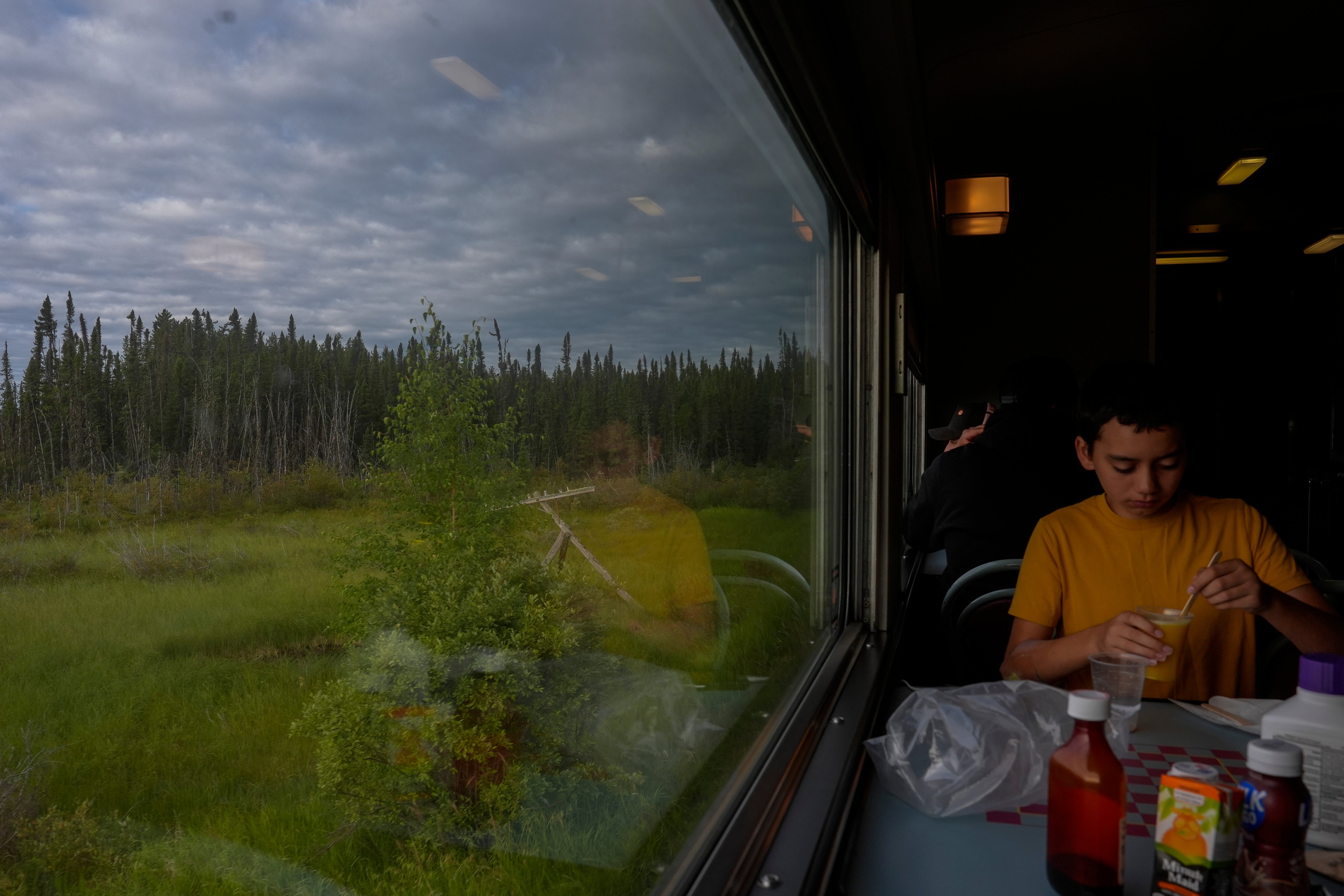 A passenger eats breakfast as a train travels Friday, August 9, 2024, near Ilford, Manitoba.