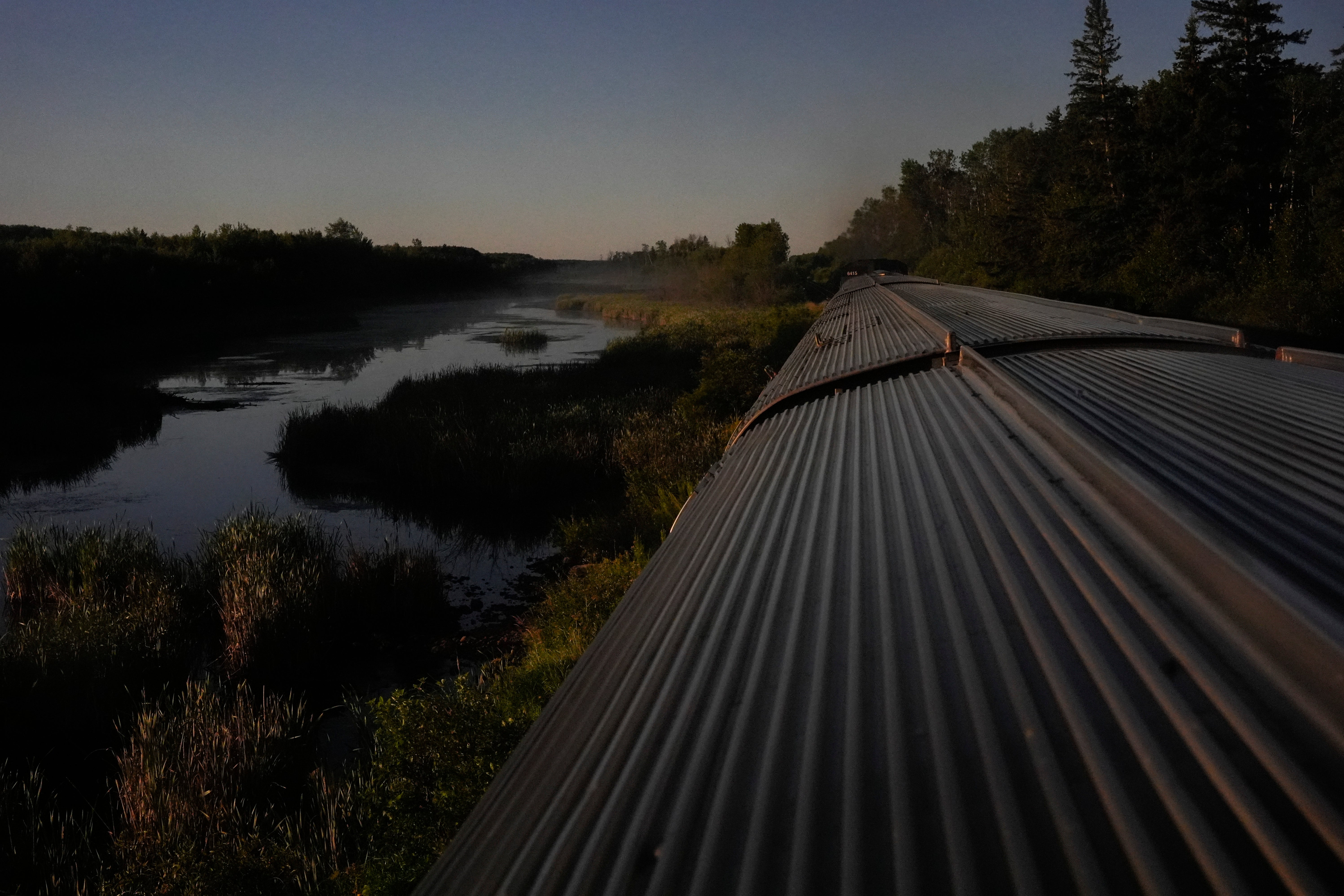 A train travels through remote wilderness Saturday, August 10, 2024, near Canora, Saskatchewan