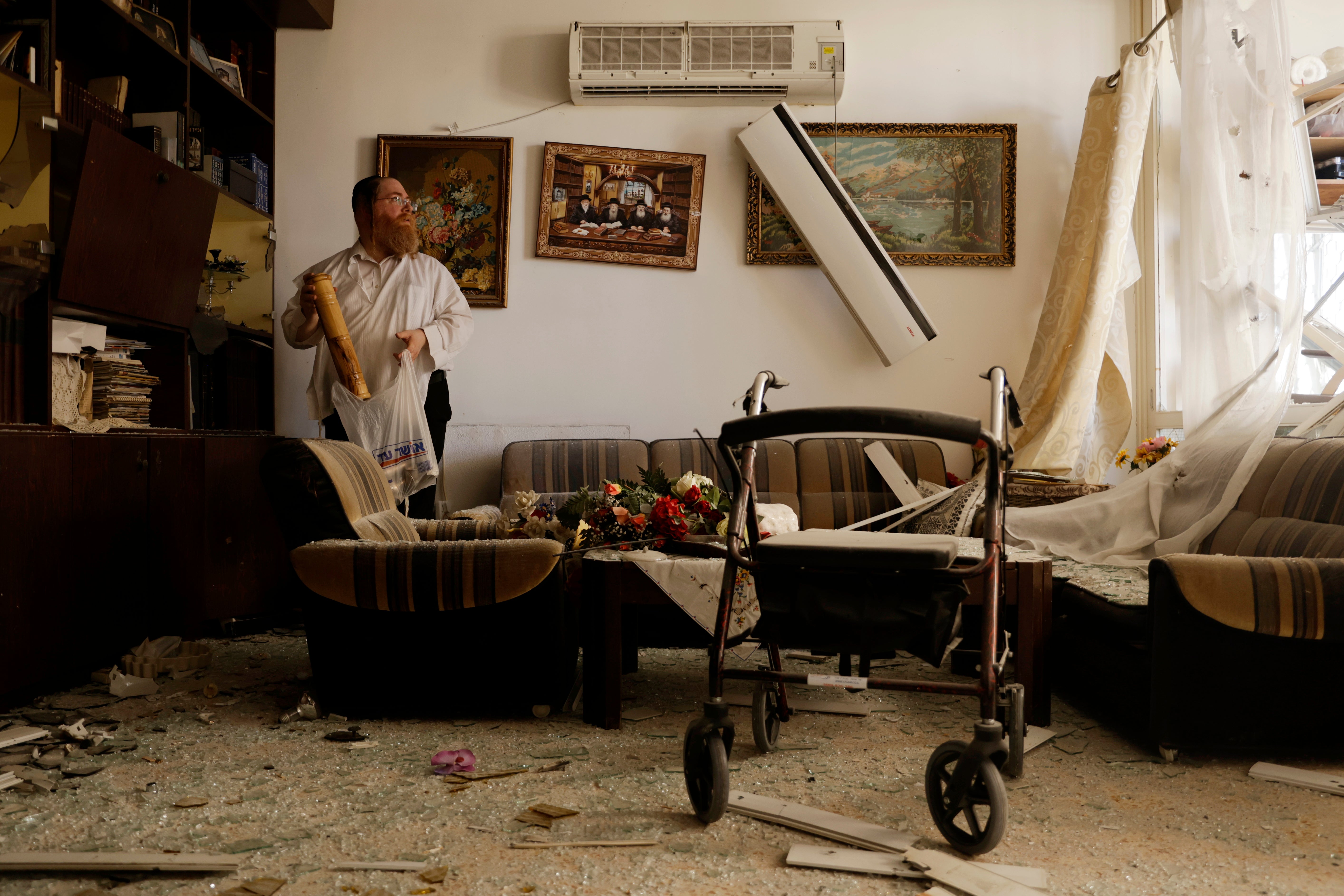 A resident inspects damage on a residential building in Haifa, Israel