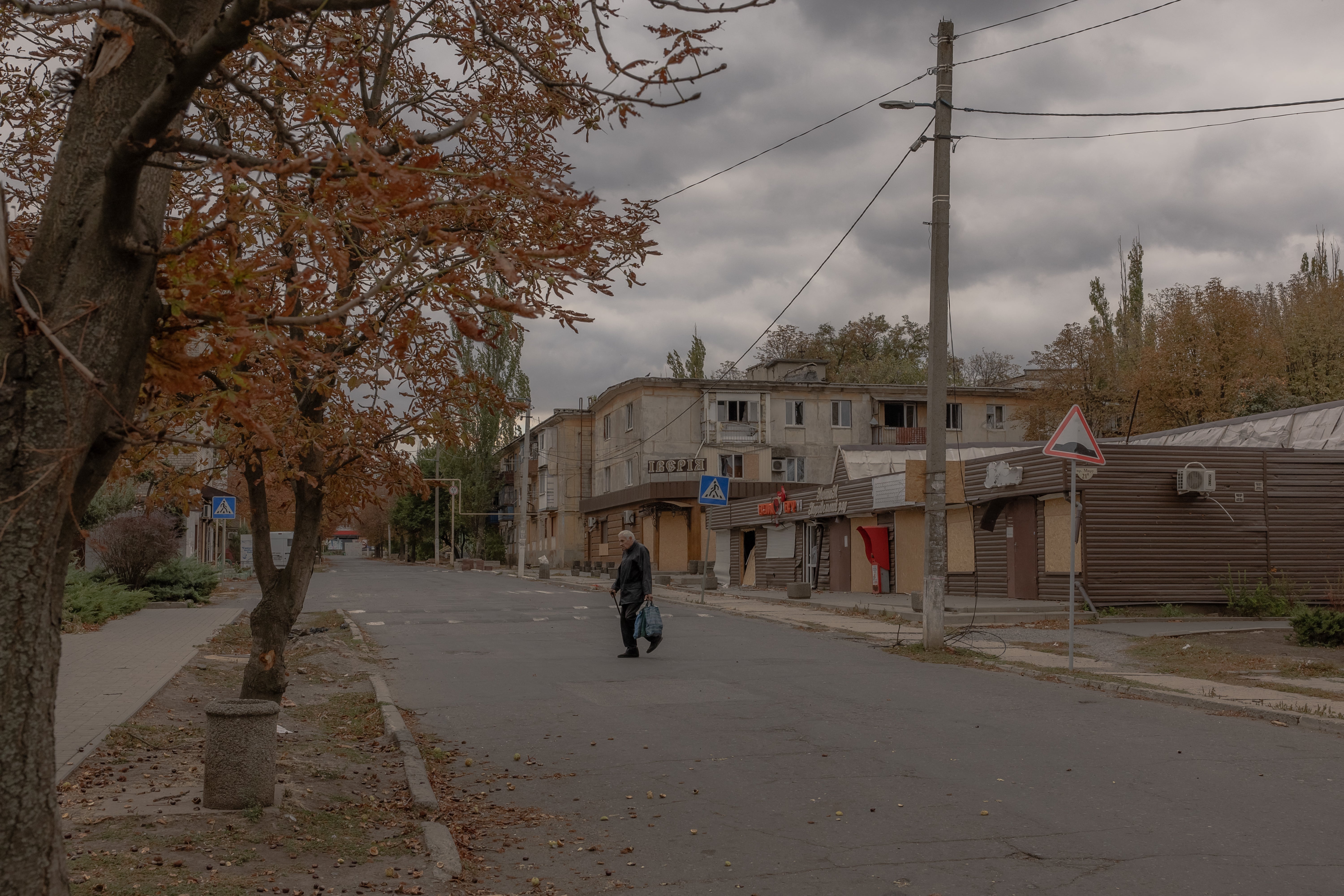 A elderly man walks across an empty street in the town of Kurakhove, near the frontline, in the Pokrovsk district