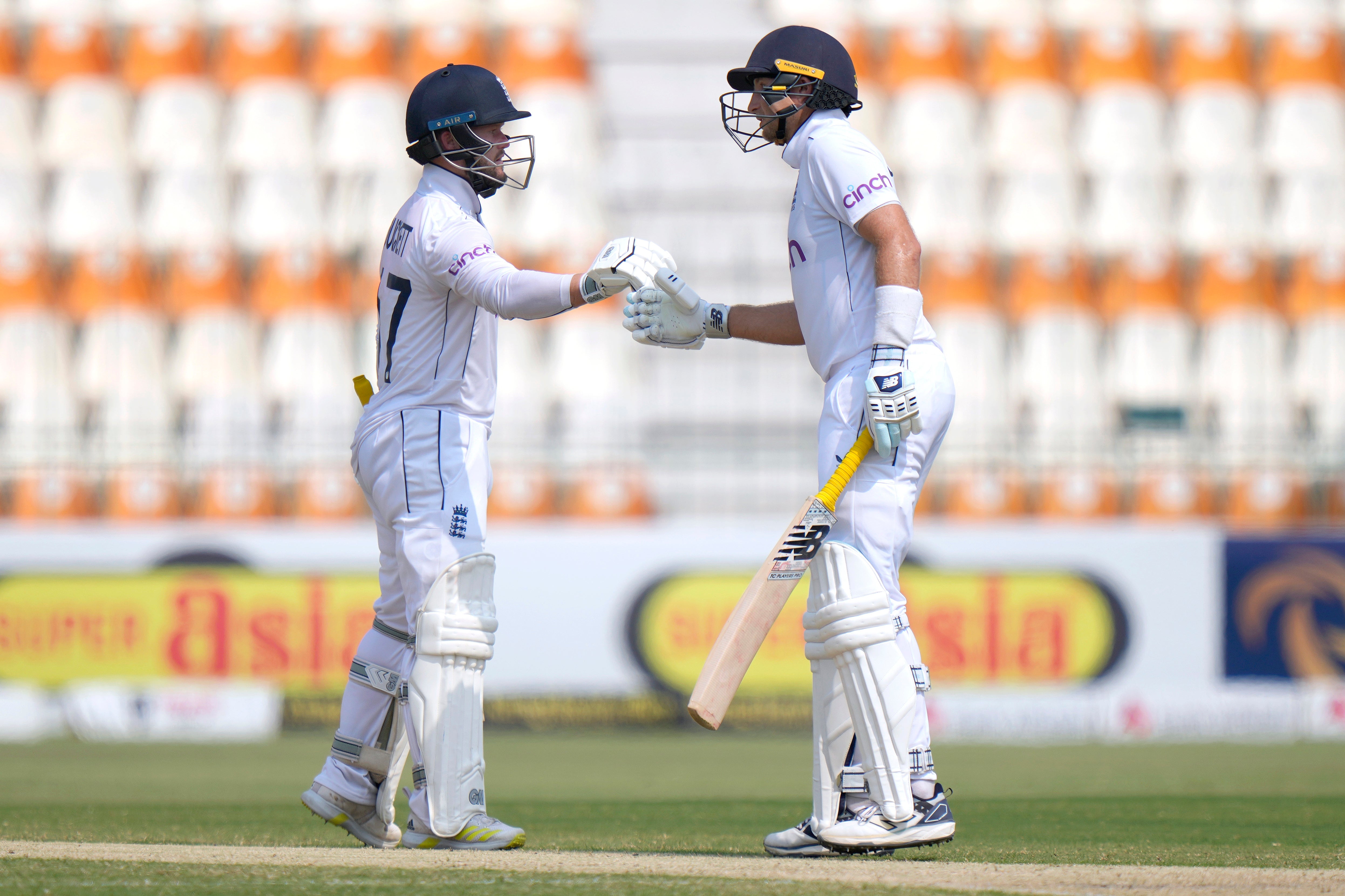 England’s Ben Duckett, left, and Joe Root bump their fists to celebrate (Anjum Naveed/AP)