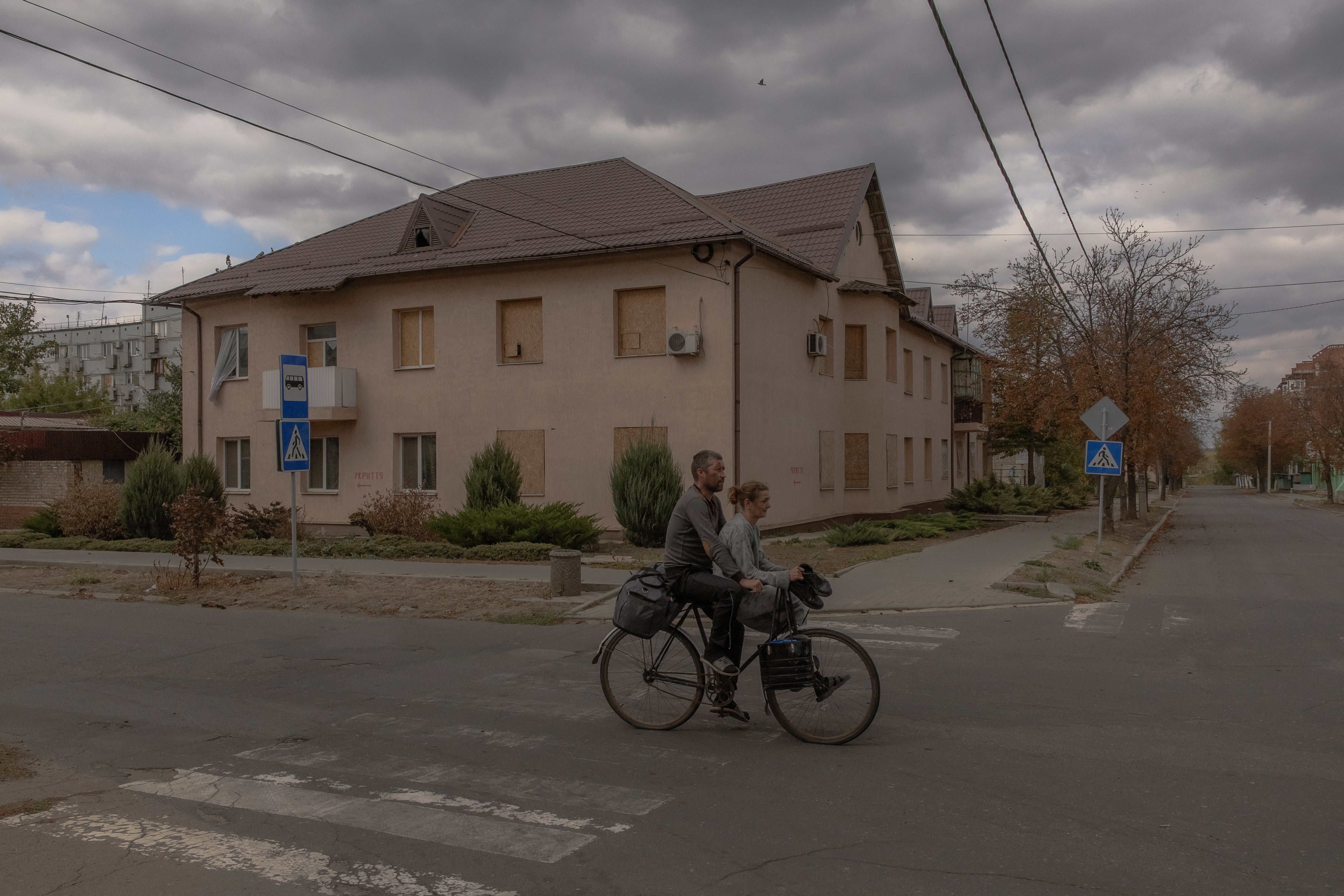 People ride on a bicycle in the town of Kurakhove, located near the front line, in the Pokrovsk district of the eastern Donetsk region, Ukraine