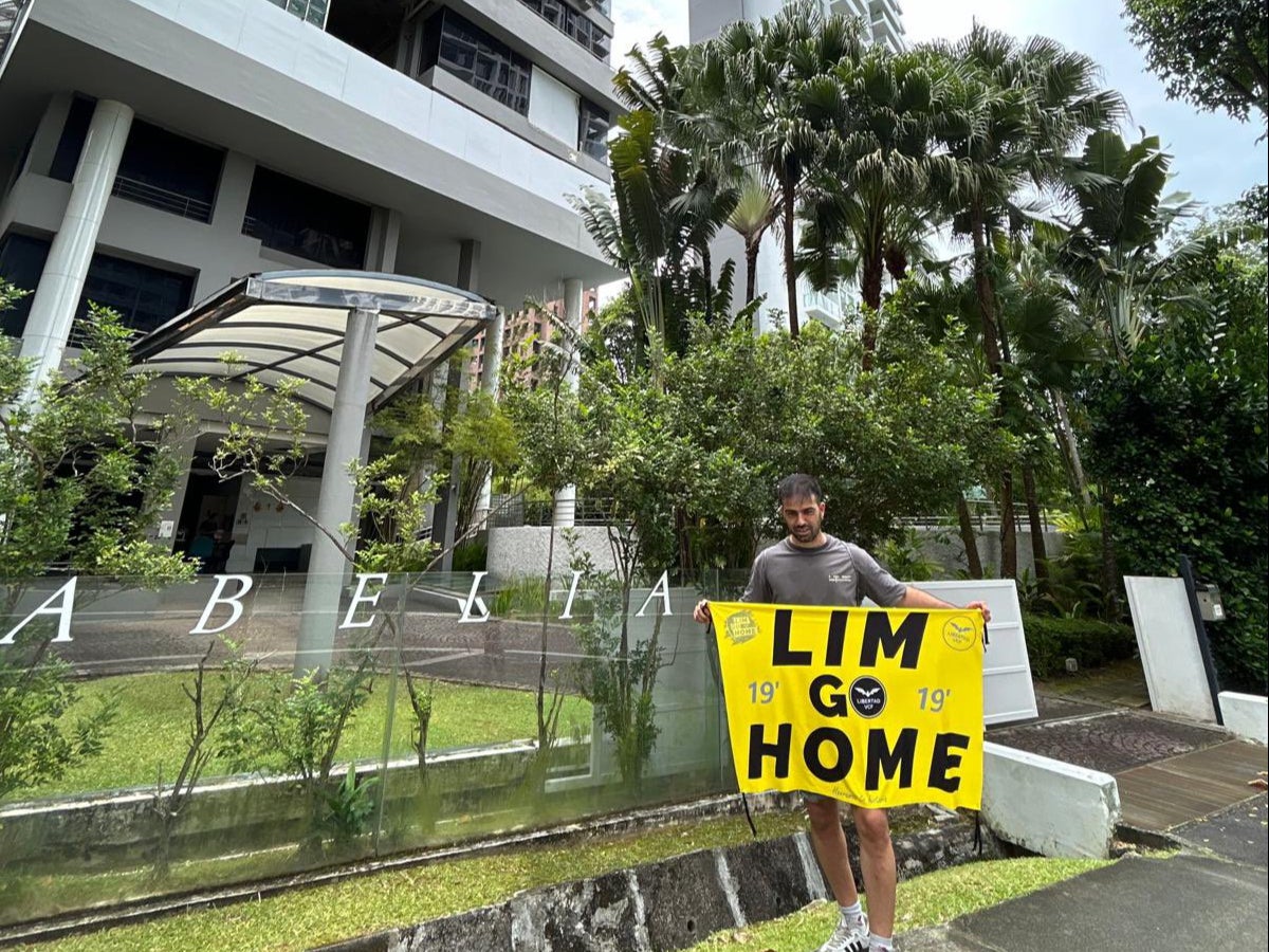 Dani Cueta shared his picture holding a banner reading ‘Lim Go Home’ outside what is believed to be billionaire Peter Lim’s house in Singapore