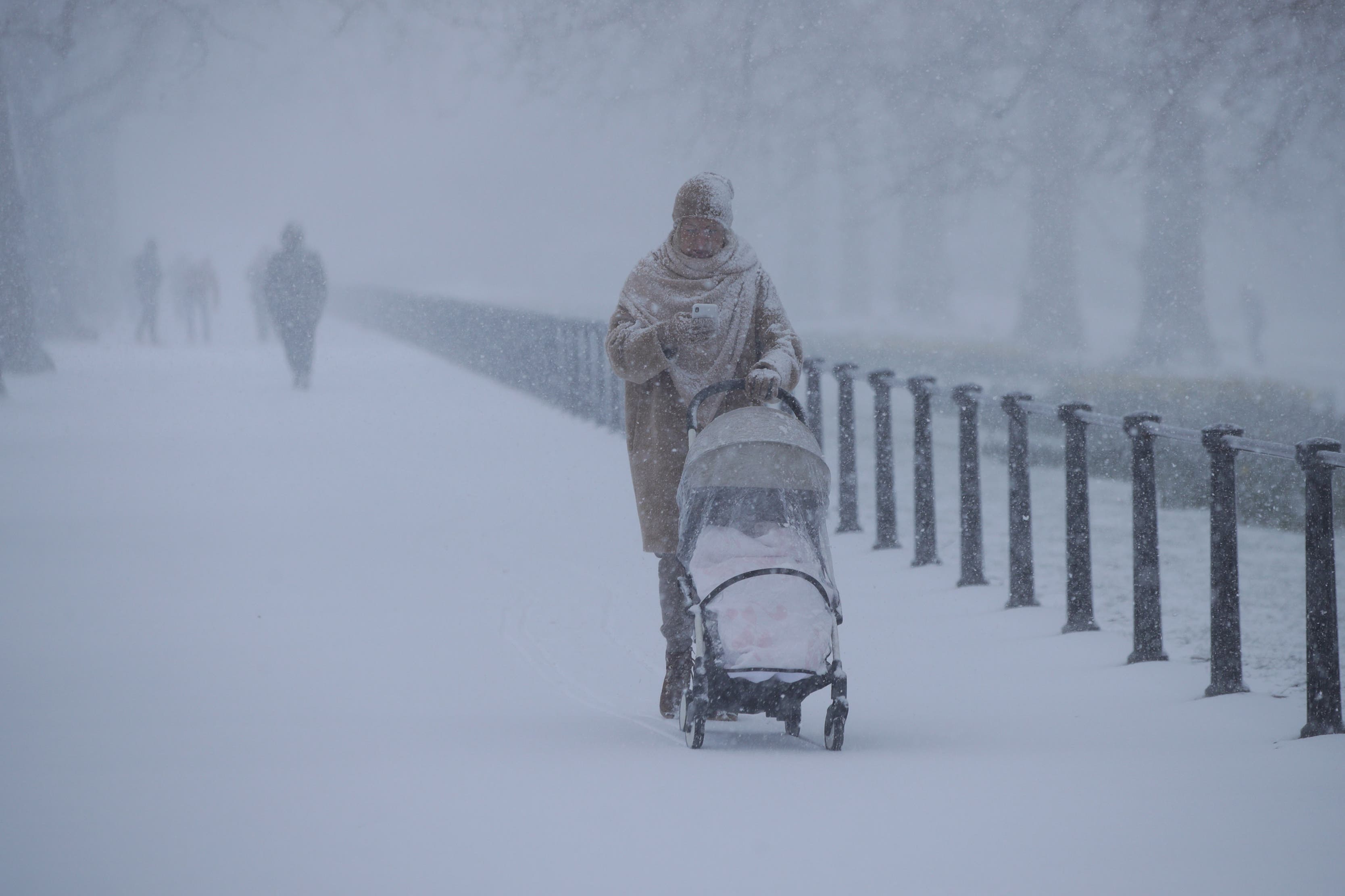 A woman pushes a baby buggy along The Mall in London (Yui Mok / PA).