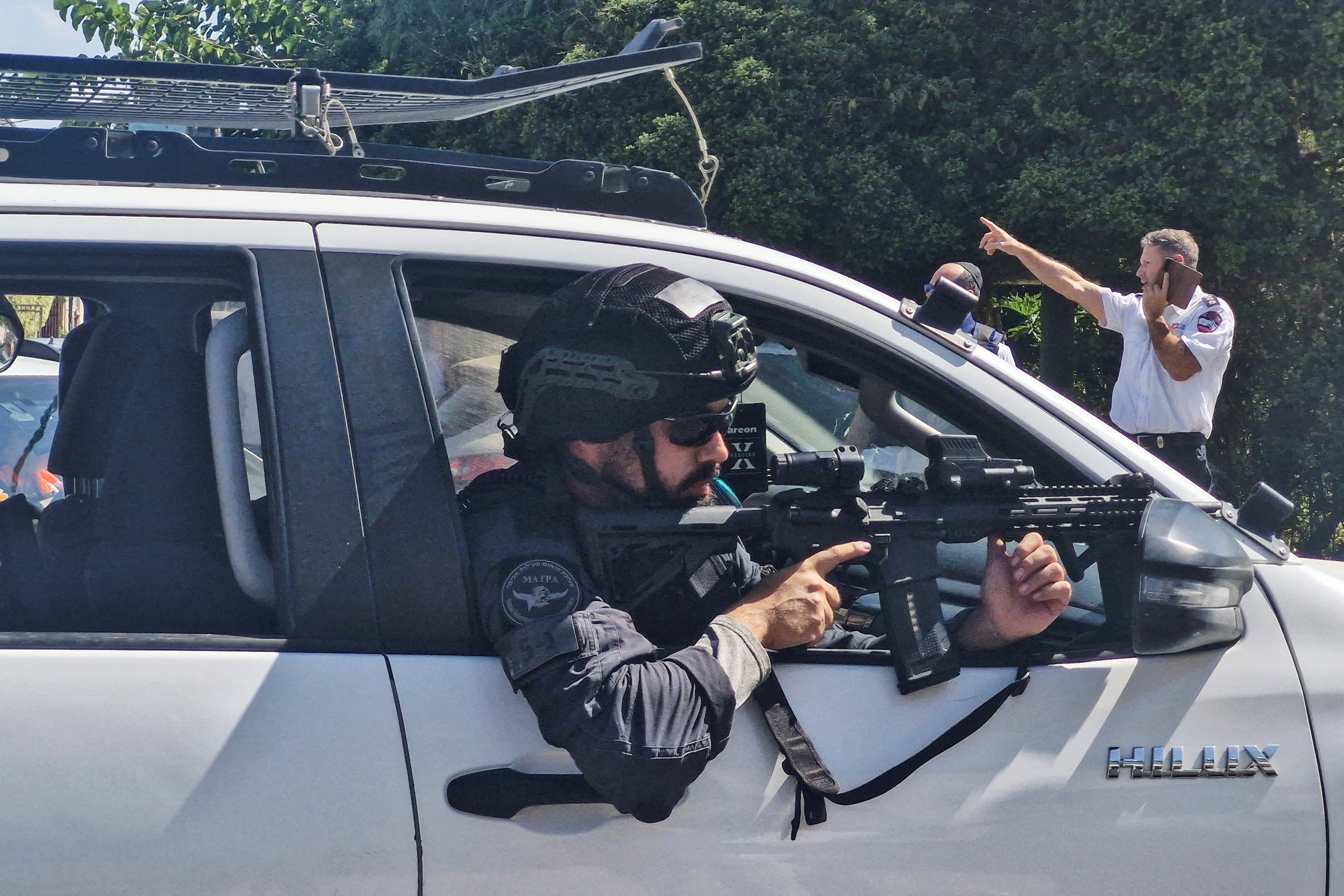 An Israeli police officer aims his gun following a suspected stabbing attack in Hadera, Israel, on Wednesday