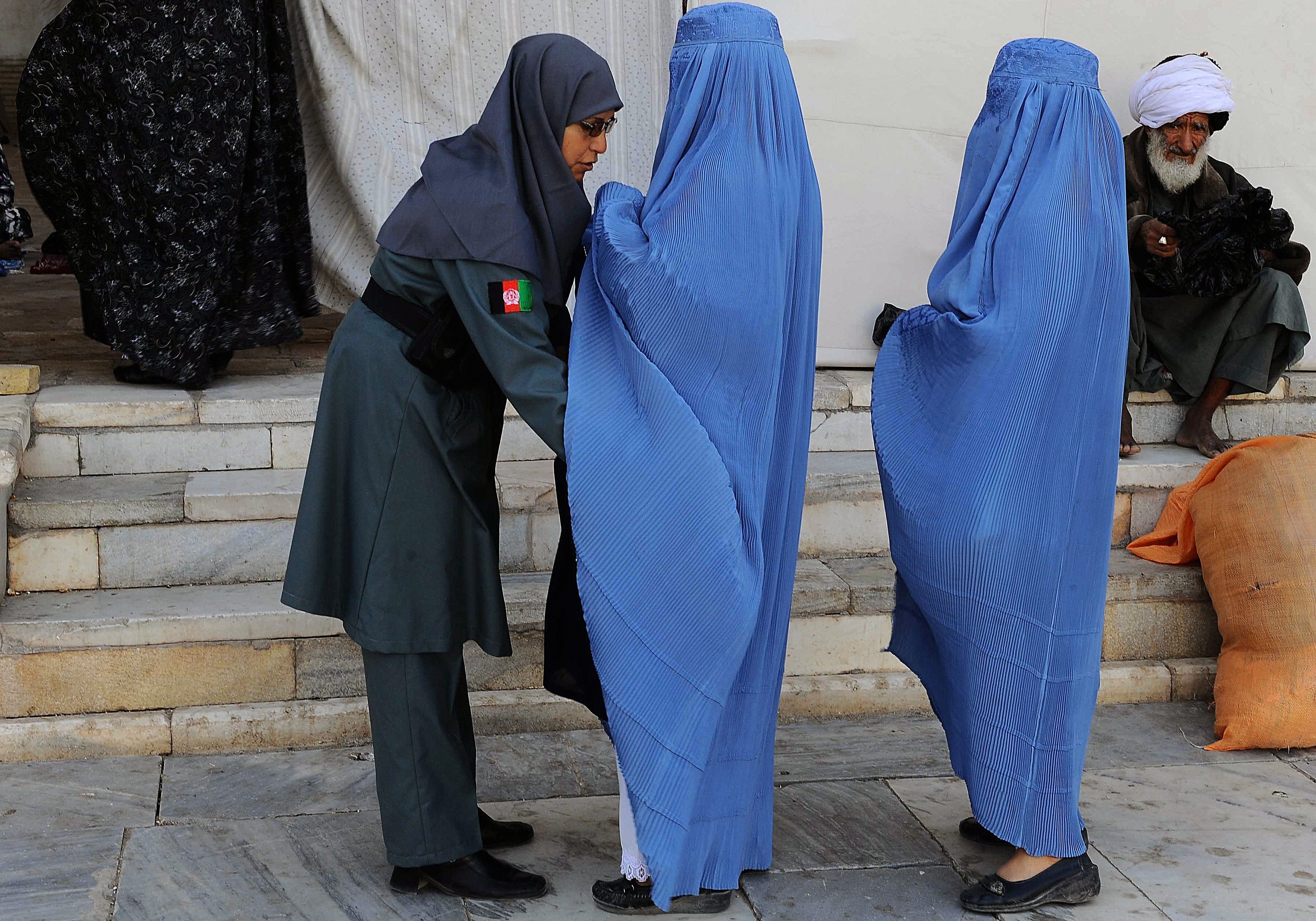 An Afghan policewoman searches worshippers arriving for Eid prayers in Herat in 2013