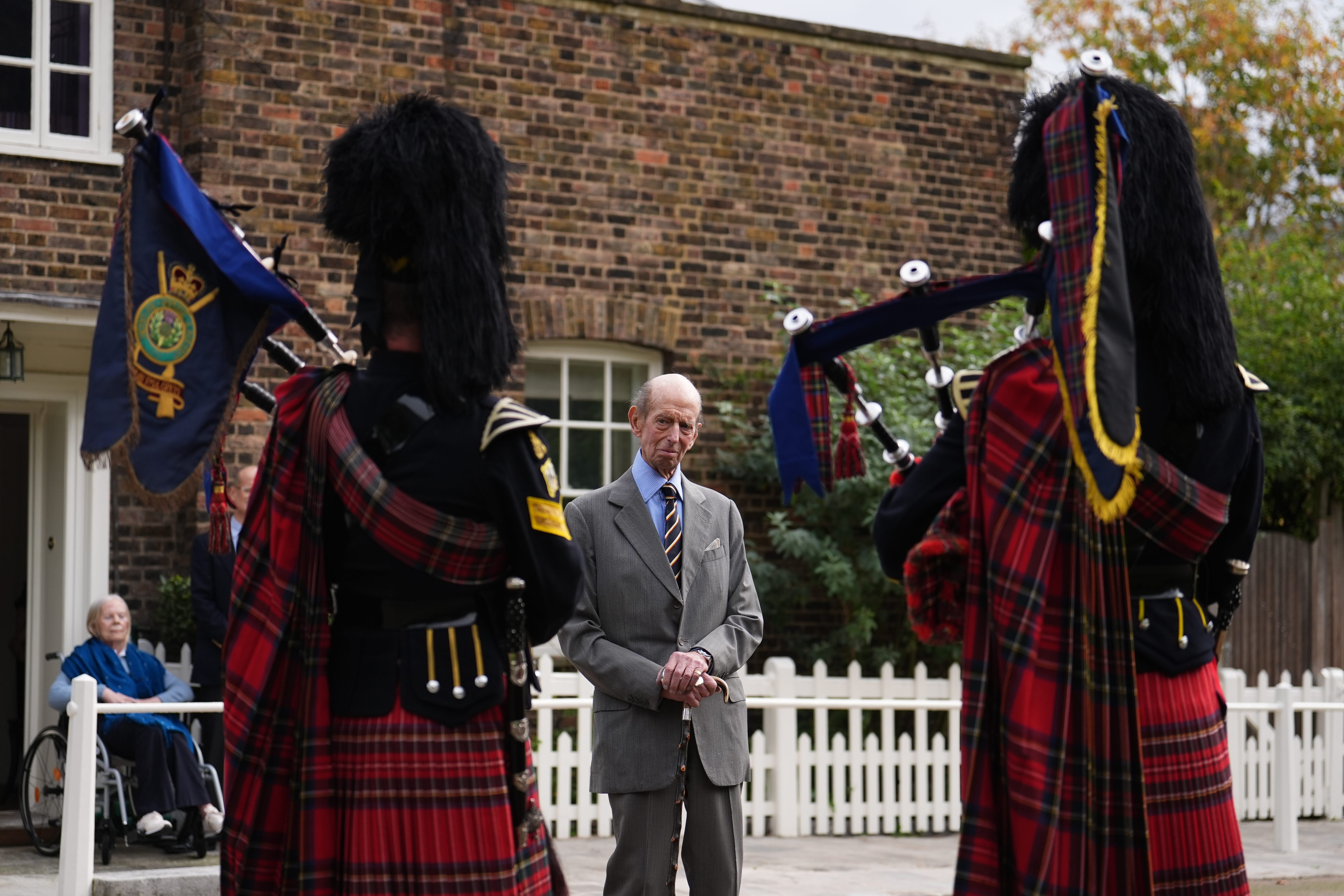 The Duchess of Kent watches her husband the Duke of Kent listening to three pipers from the Royal Scots Dragoon Guards on his 89th birthday (Jordan Pettitt/PA)