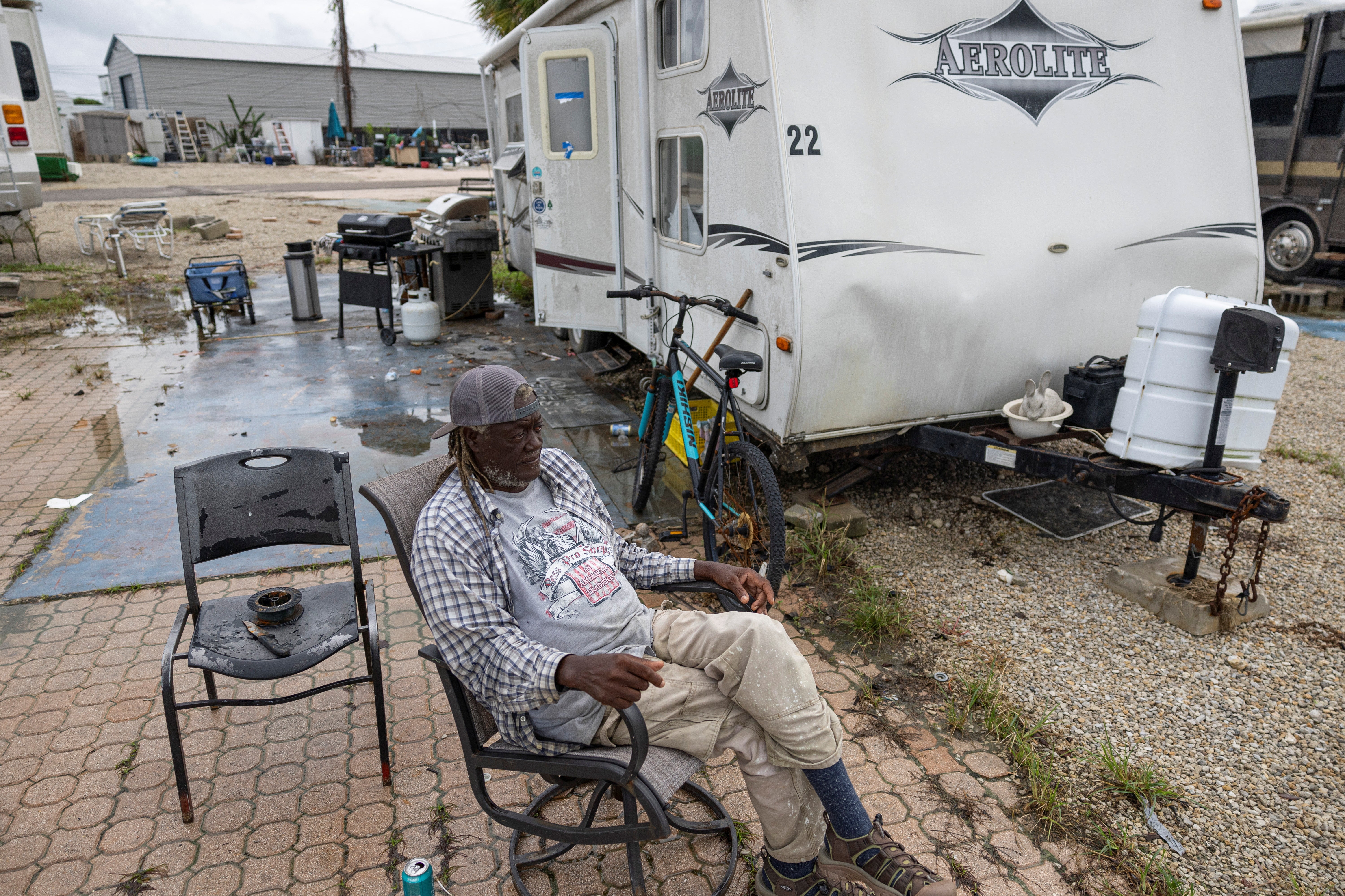 A man sits in front of his camper in Fort Myers, Florida as he waits for it to be towed to safe ground ahead of Hurricane Milton on Wednesday morning