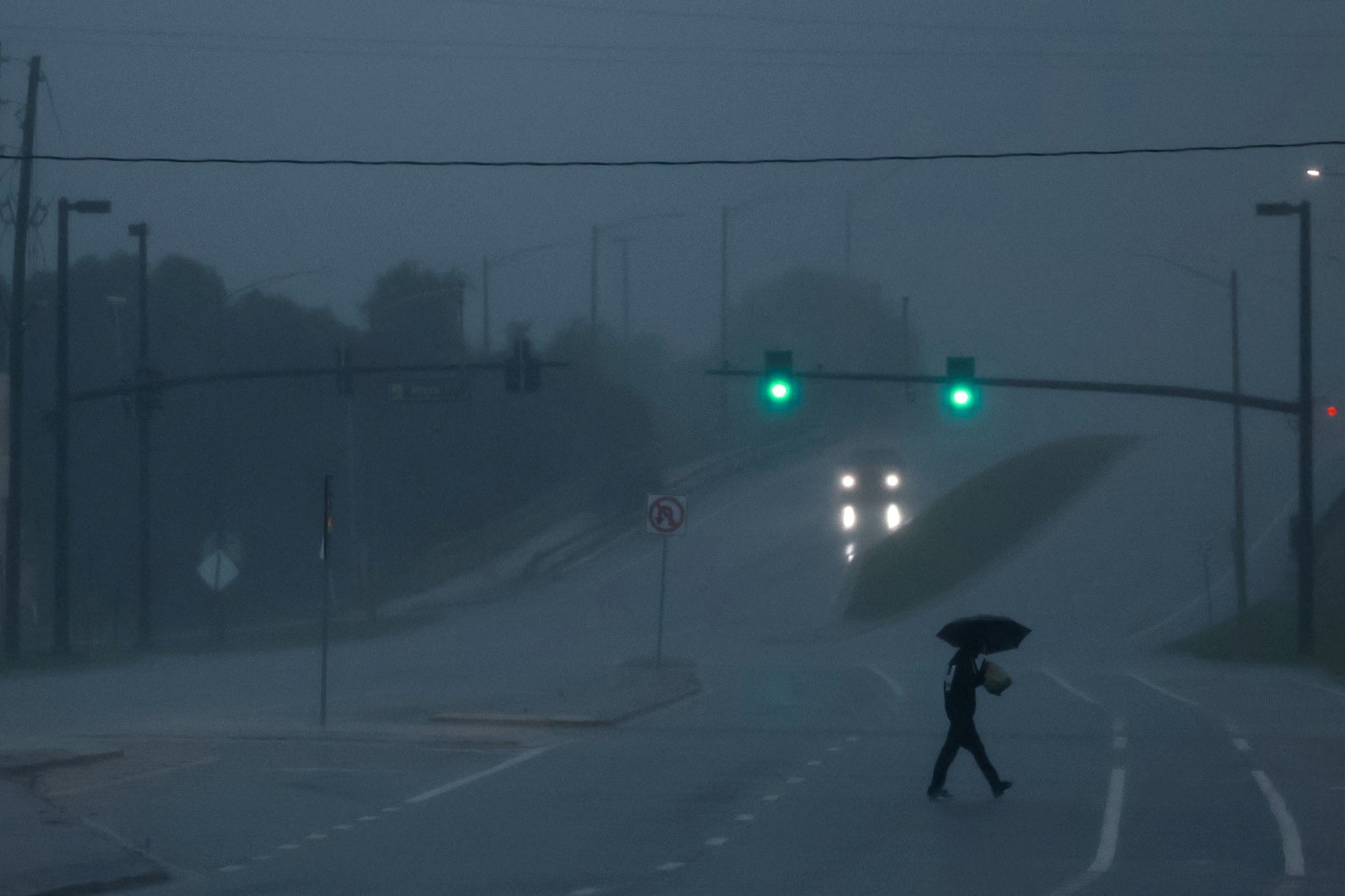 A man walks down an avenue as Hurricane Milton approaches Orlando, Florida, on Wednesday.