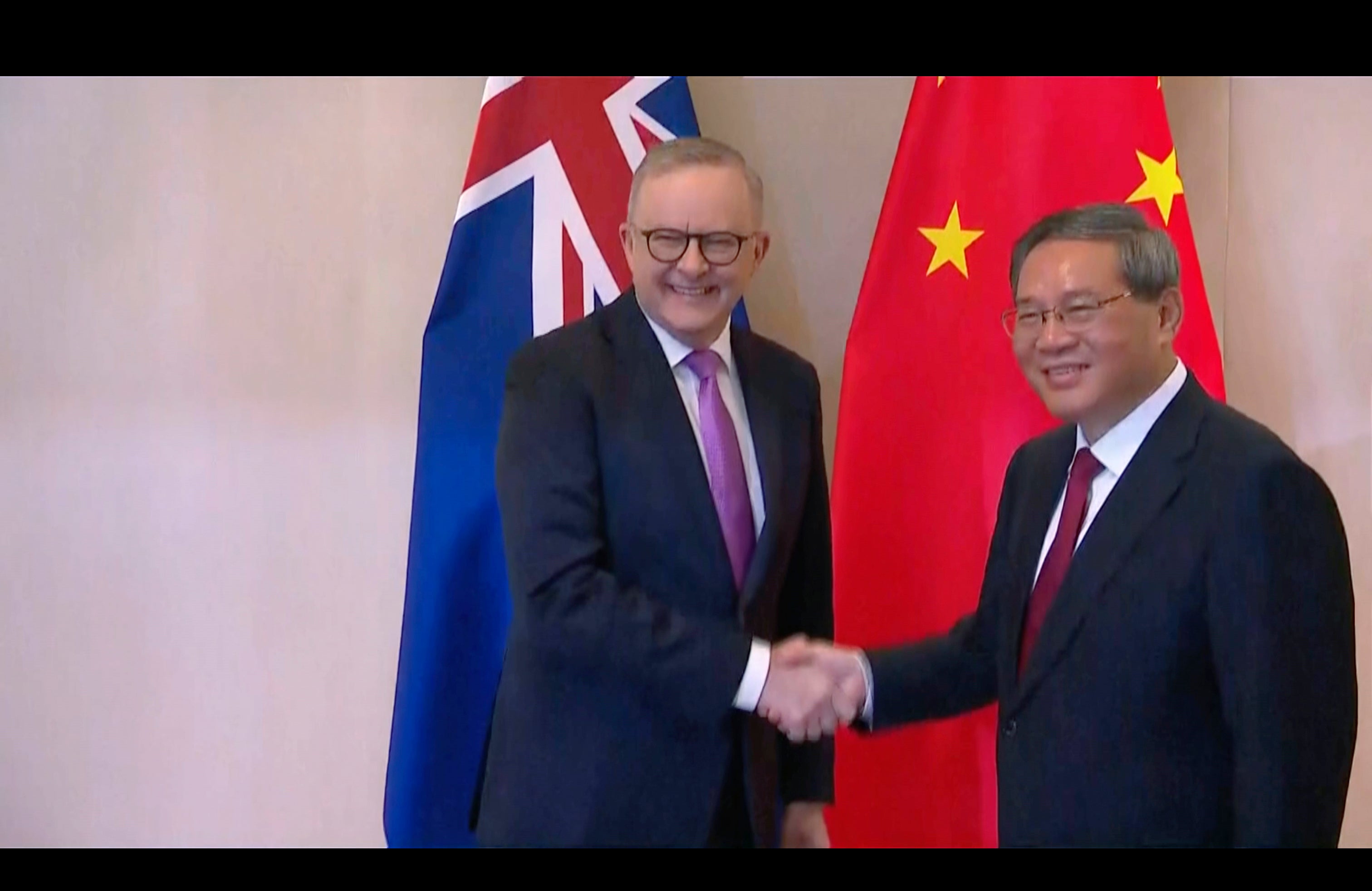 Anthony Albanese shakes hands with Li Qiang on the sidelines of the summit
