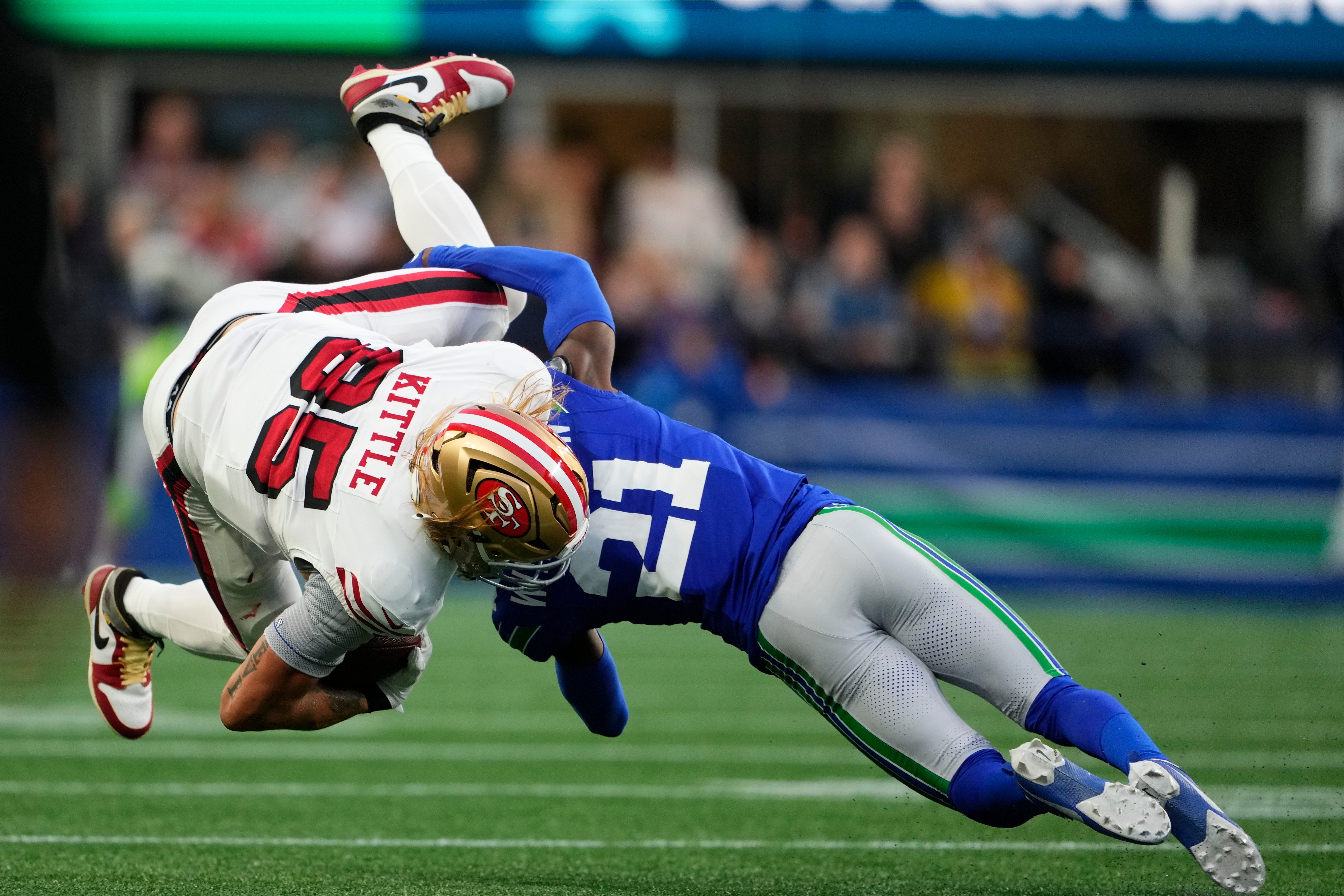 San Francisco 49ers’ George Kittle is tacked by Seattle Seahawks’ Devon Witherspoon (Lindsey Wasson/AP)