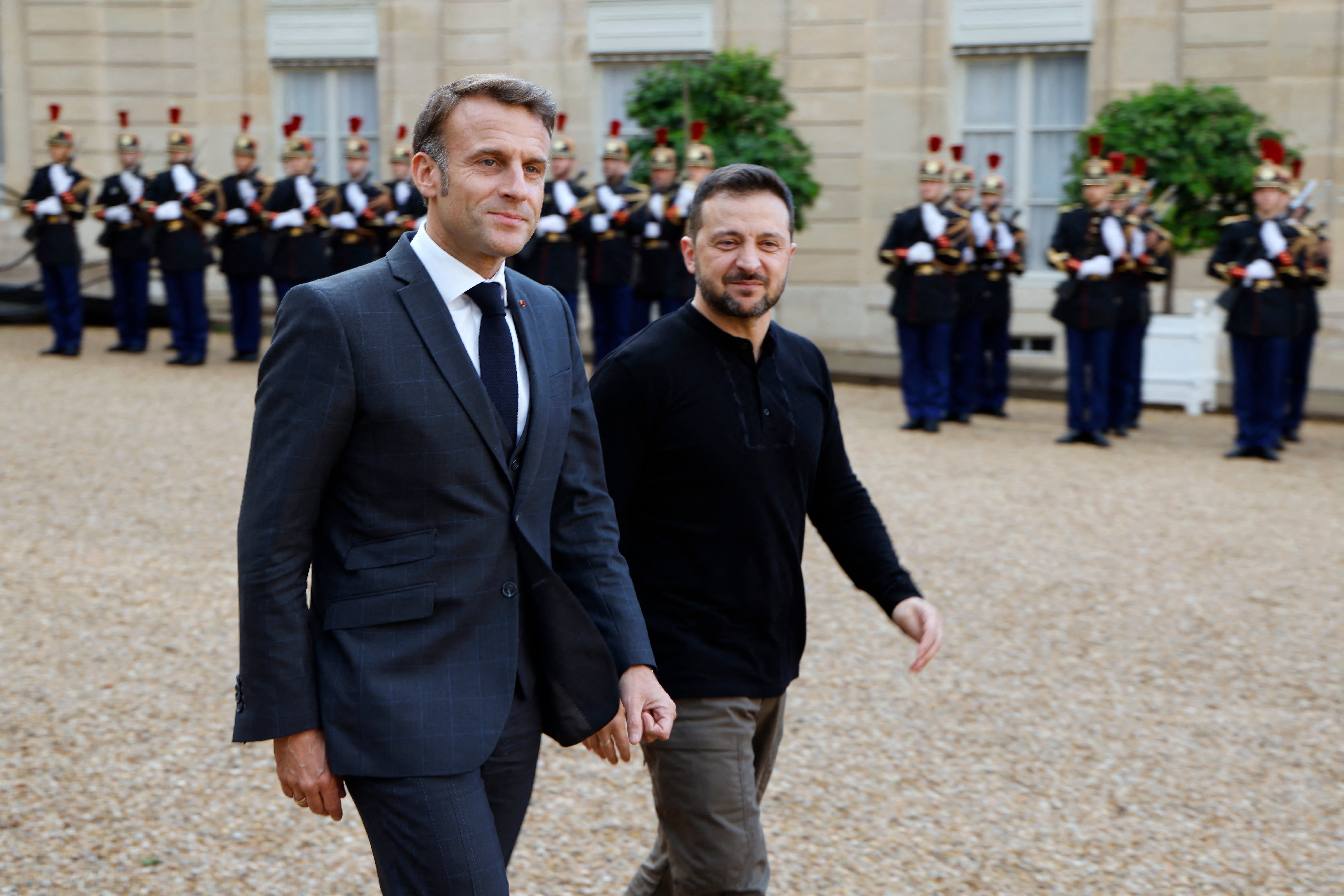 France's president Emmanuel Macron walks out Volodymyr Zelensky after a meeting at the Elysee Palace in Paris