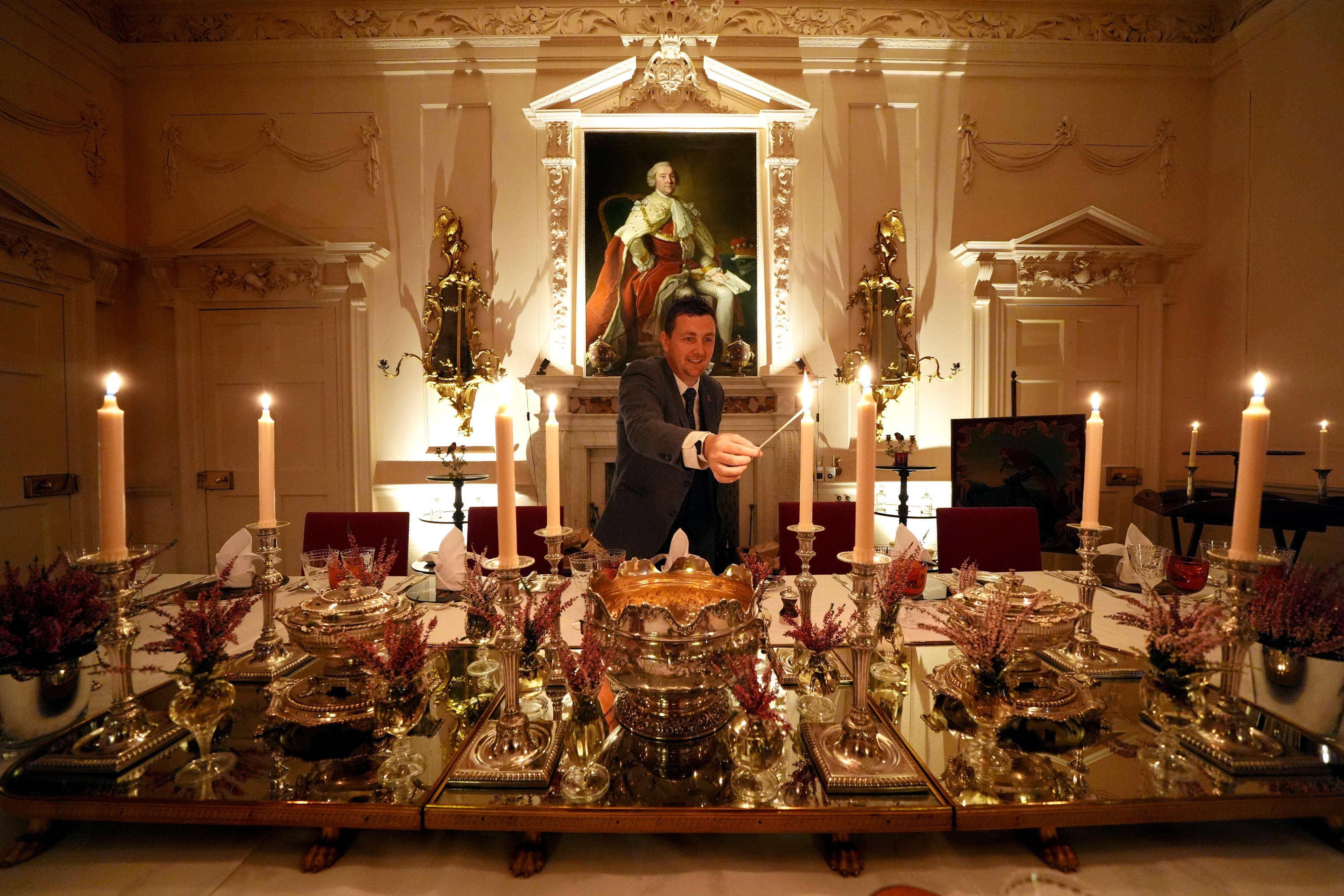 Evan Samson, who leads the front of house team at Dumfries House, lights candles as he puts the finishing touches to the Pink Dining Room – the King’s favourite room at Dumfries House in Cumnock, Ayrshire (Andrew Milligan/PA)