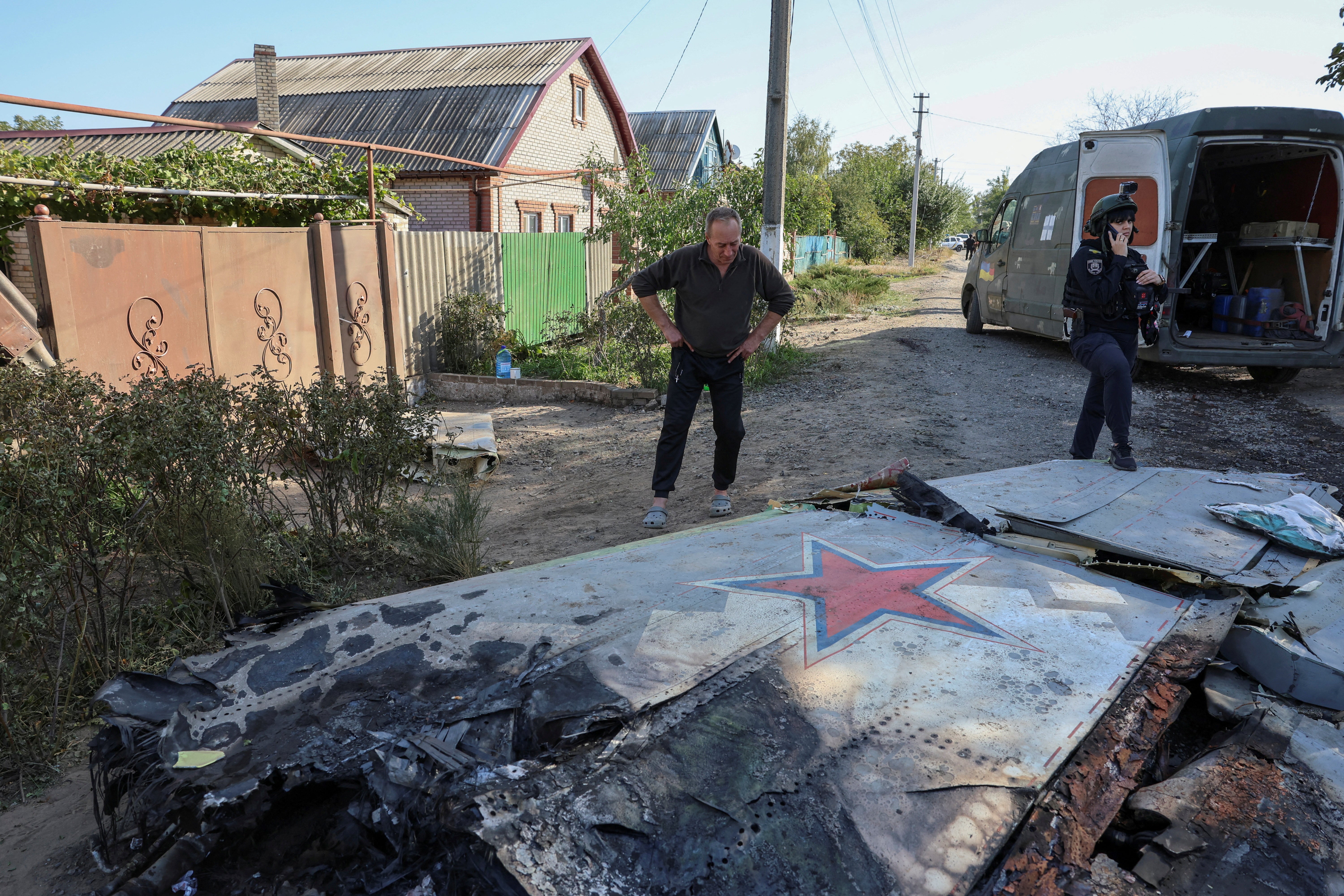 A local man looks at a part of a Russian aerial vehicle, which local authorities assume to be a newest heavy unmanned aerial vehicle S-70 Okhotnik (Hunter)