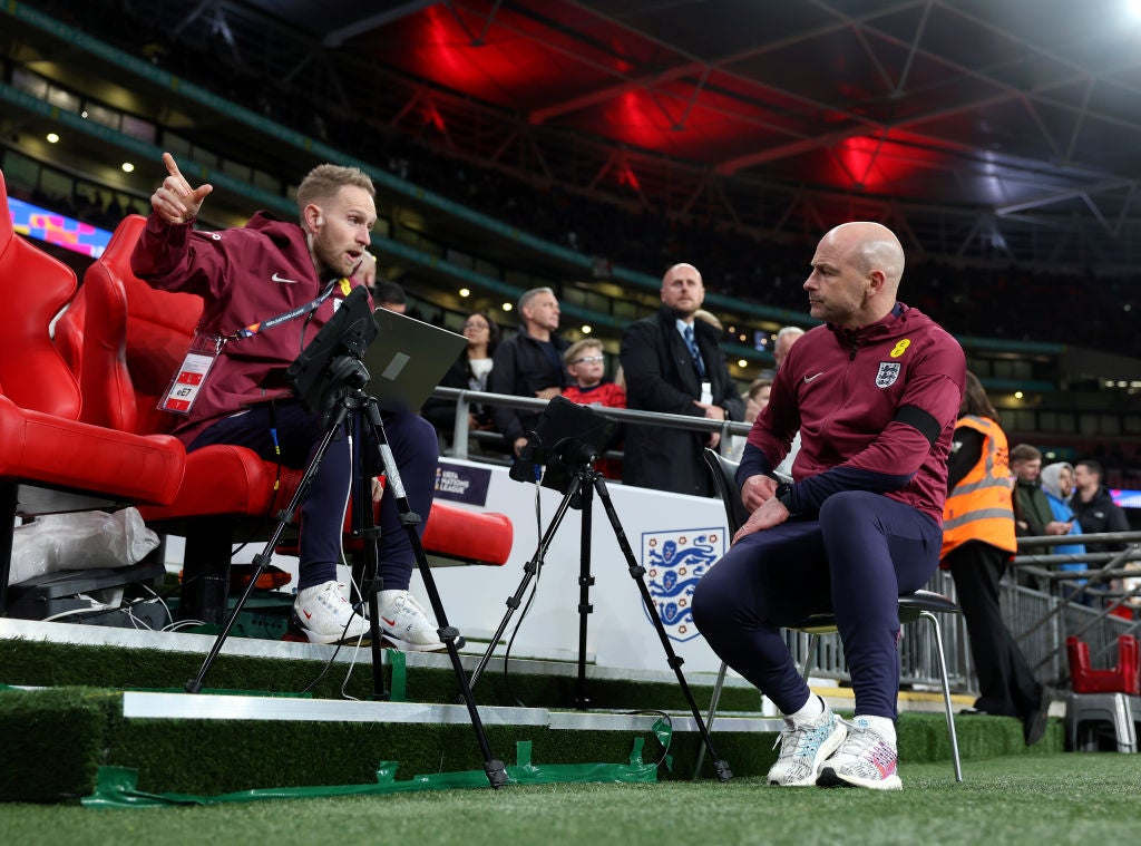 Carsley (right) talks to England performance analyst James Ryder during the Greece game on Thursday