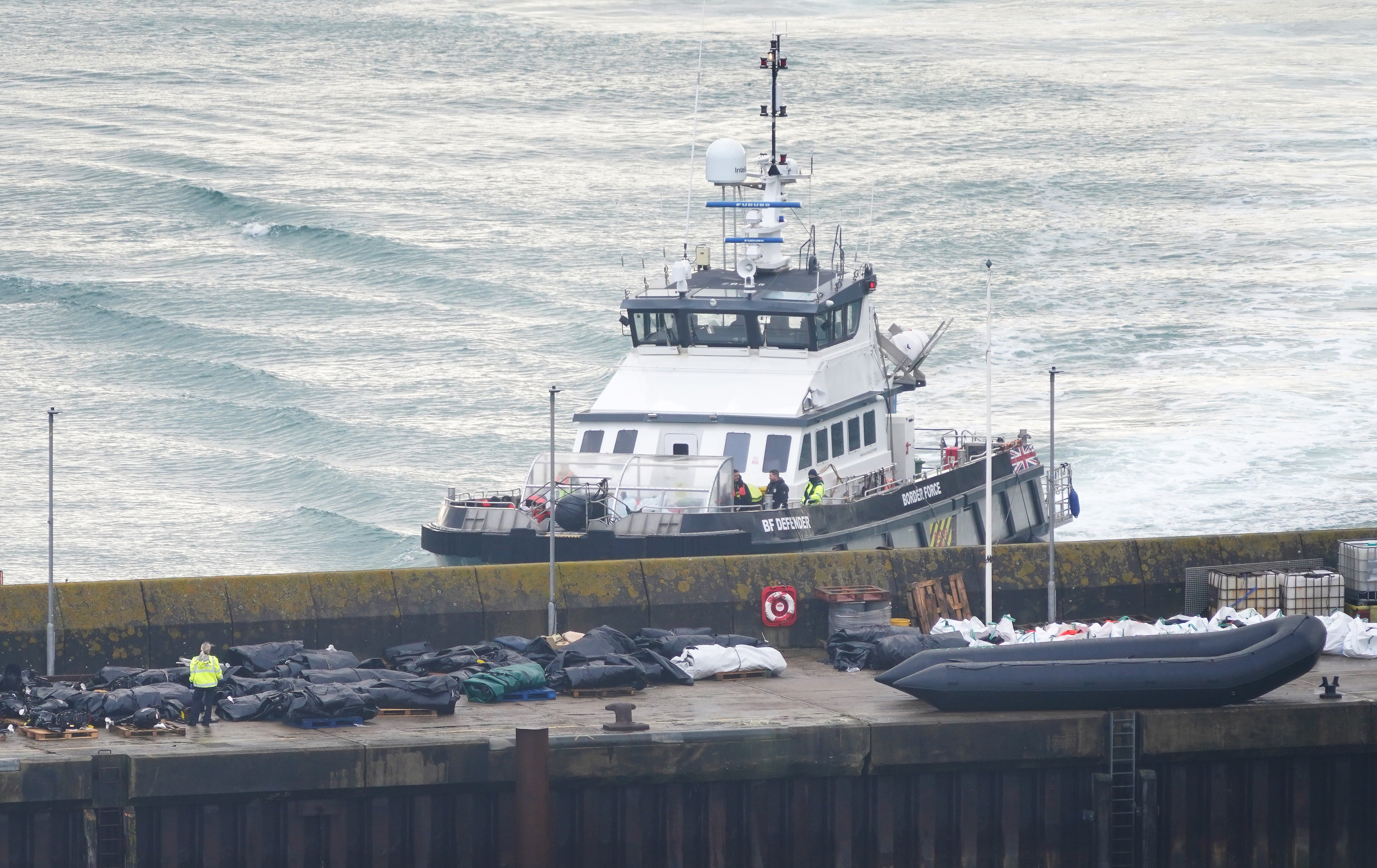 Border Force officers investigate boats thought to be used by migrants on the dockside in Dover, Kent