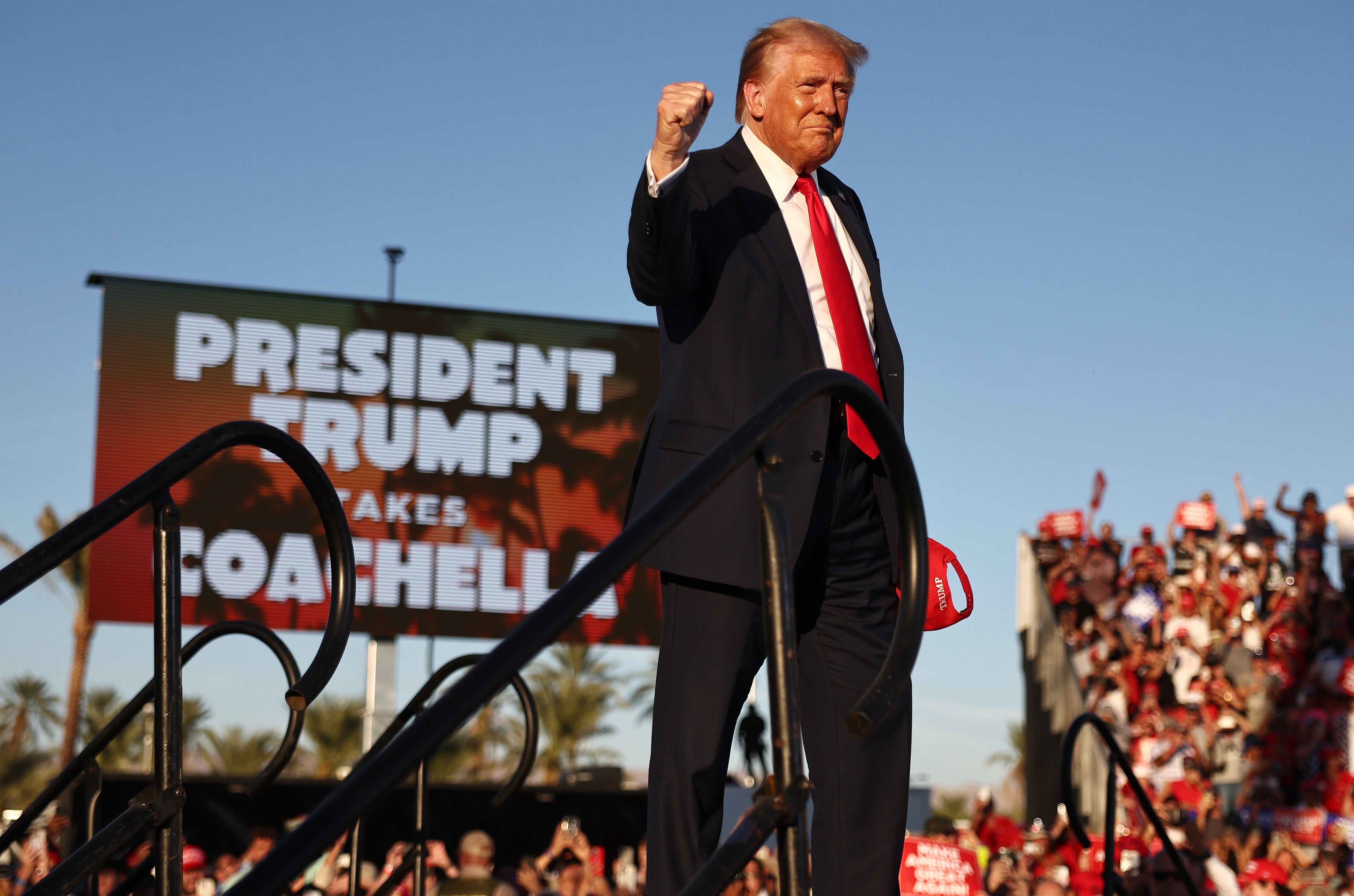 Donald Trump gestures while walking onstage for a campaign rally on October 12, 2024 in Coachella, California. The former president suggested a woman heckling him in the crowd should face physical violence