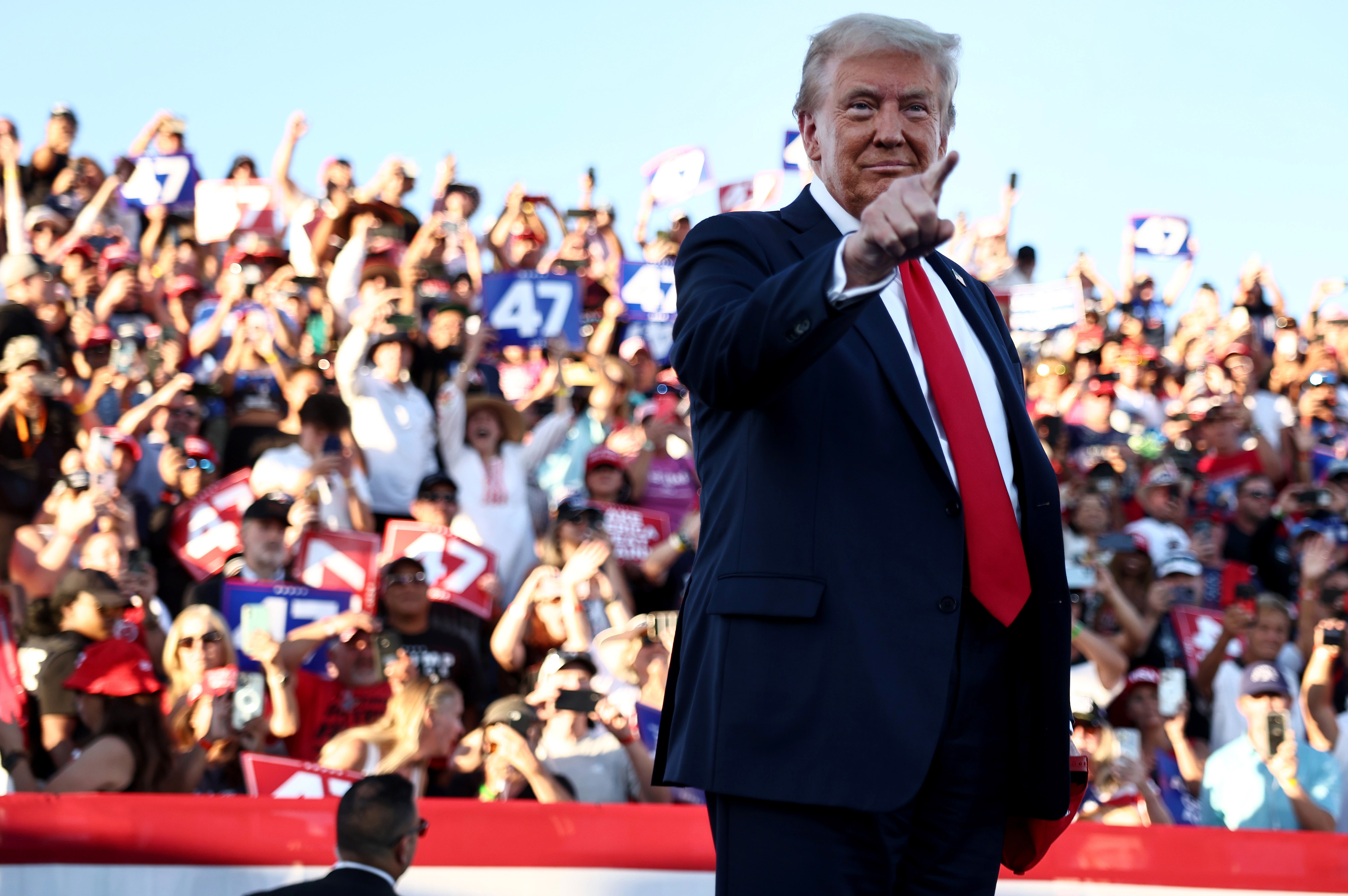 Trump points as he walks onstage for a campaign rally on October 12, 2024 in Coachella, California