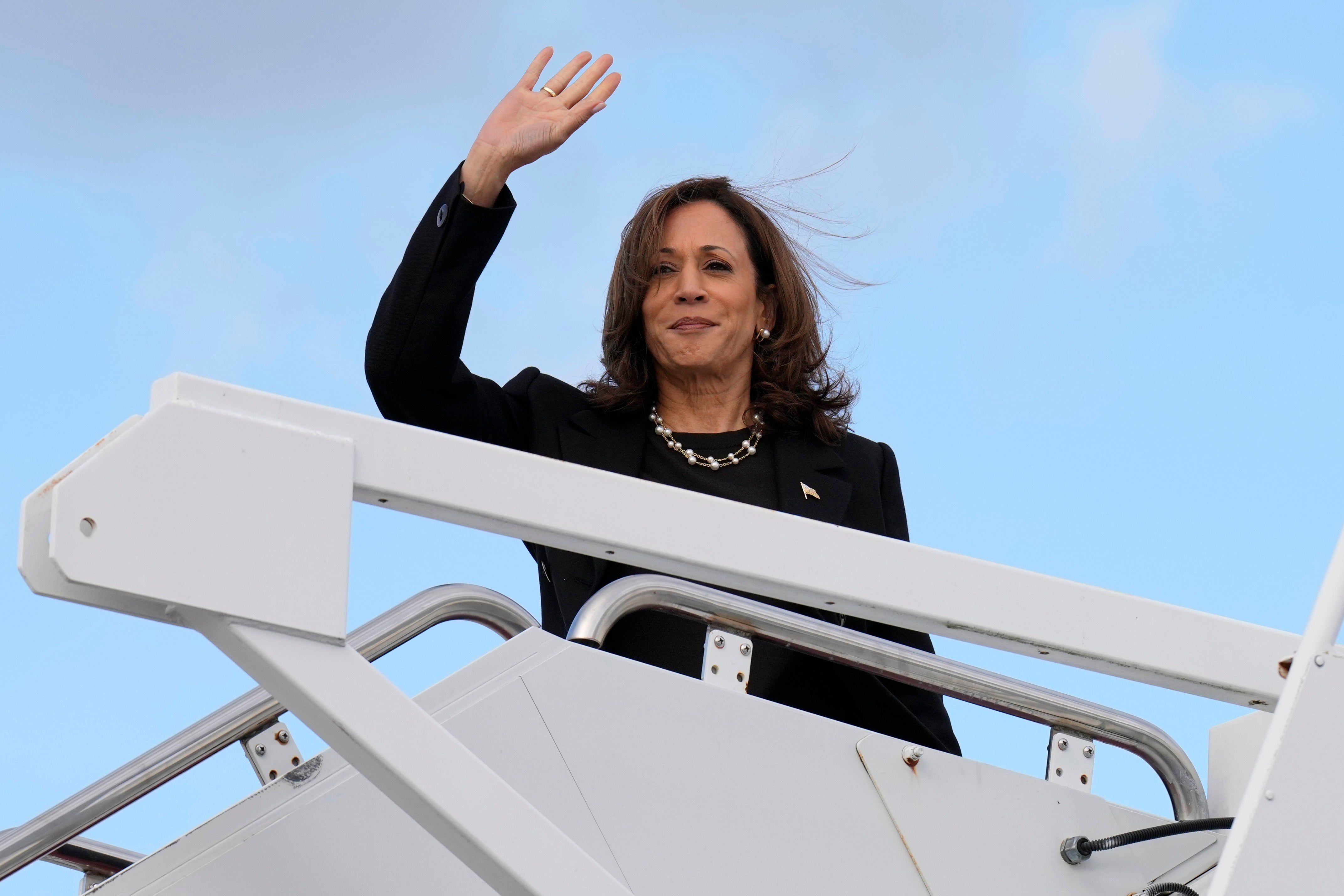 Democratic presidential nominee Vice President Kamala Harris waves as she boards Air Force Two at Joint Base Andrews