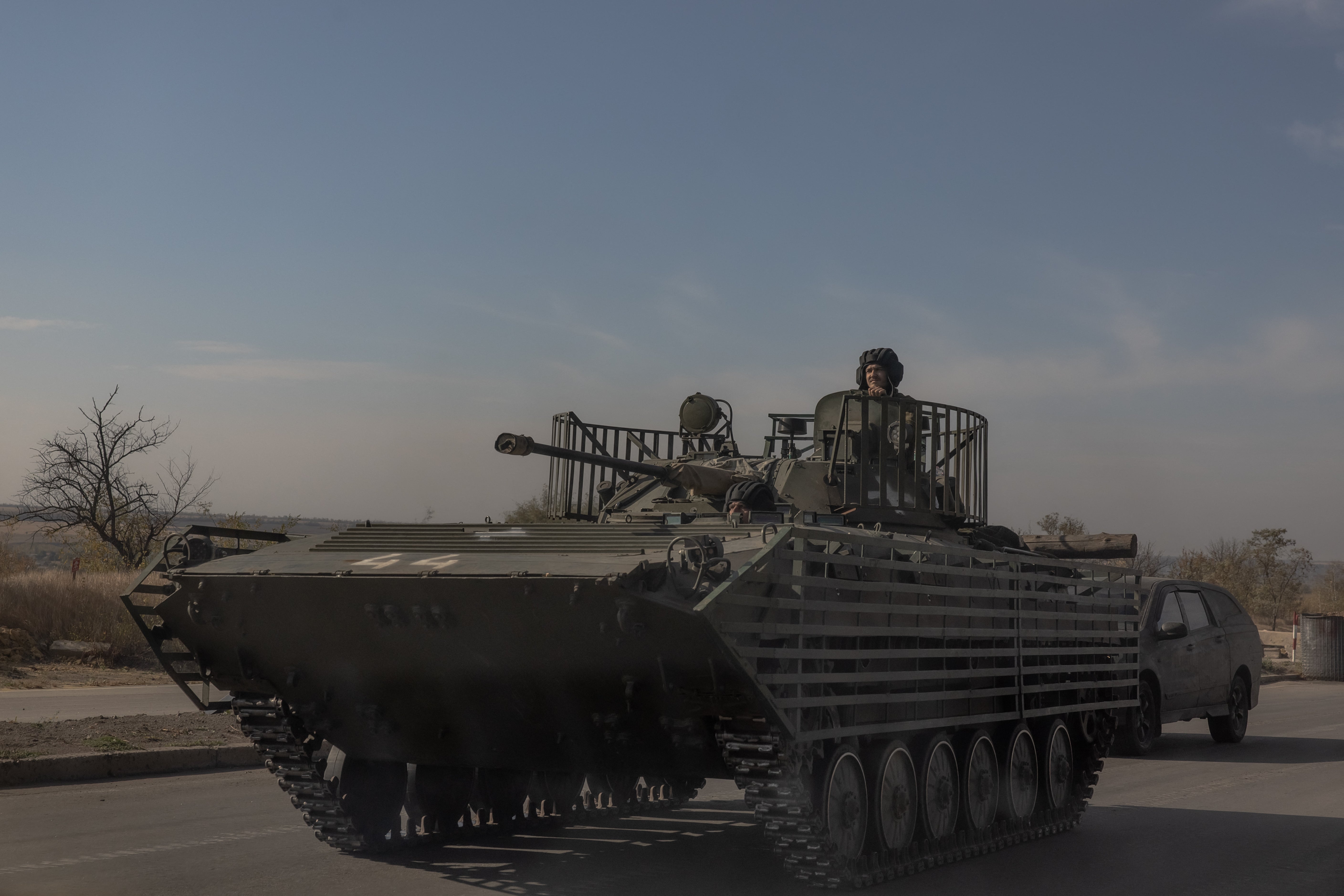 Ukrainian servicemen ride a tank on a road in the Donetsk region