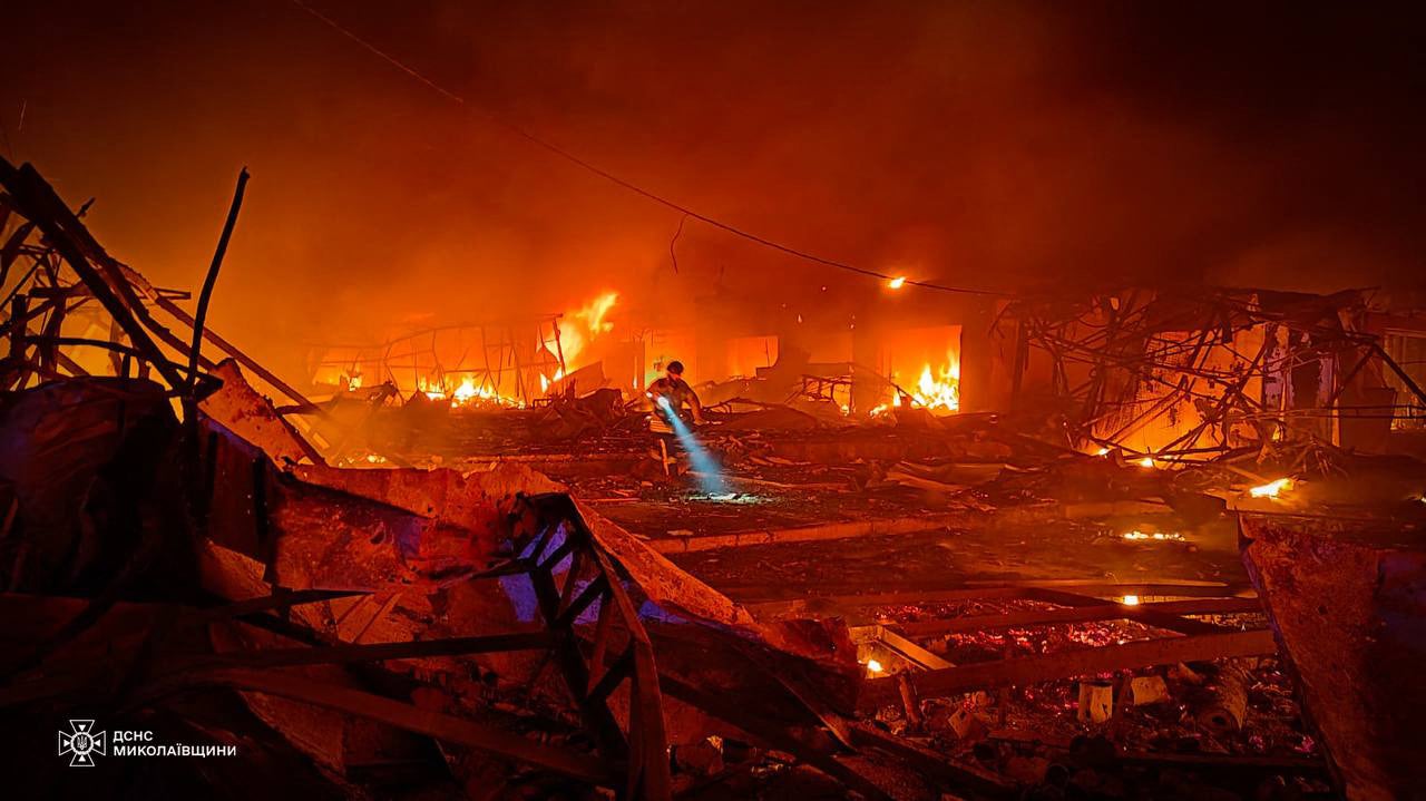 A firefighter searches through scorched rubble