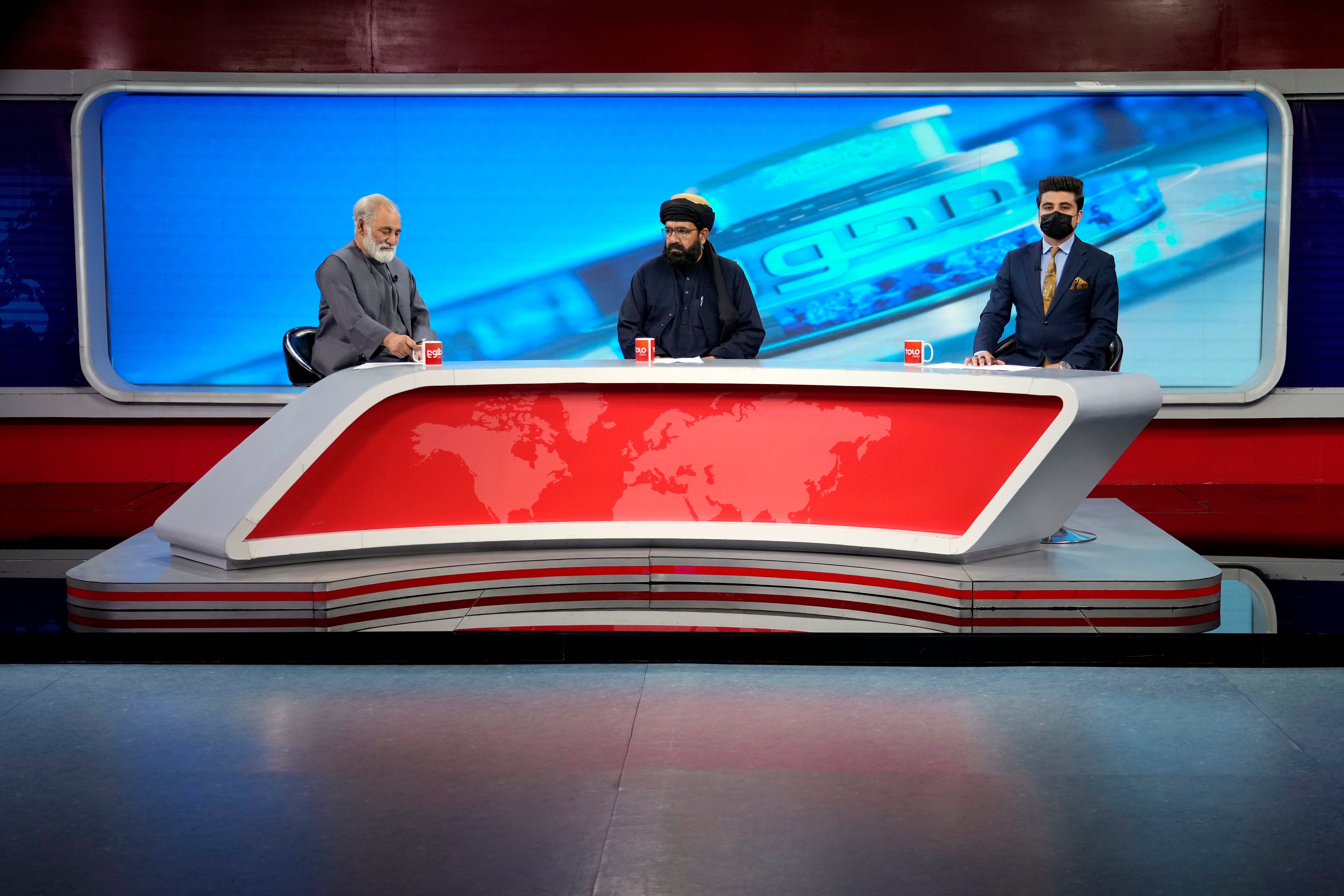 TV anchor Nesar Nabil wears a face mask to protest the Taliban's new order that female presenters cover their faces, as he reads the news on TOLOnews, in Kabul, Afghanistan, Sunday, May 22, 2022