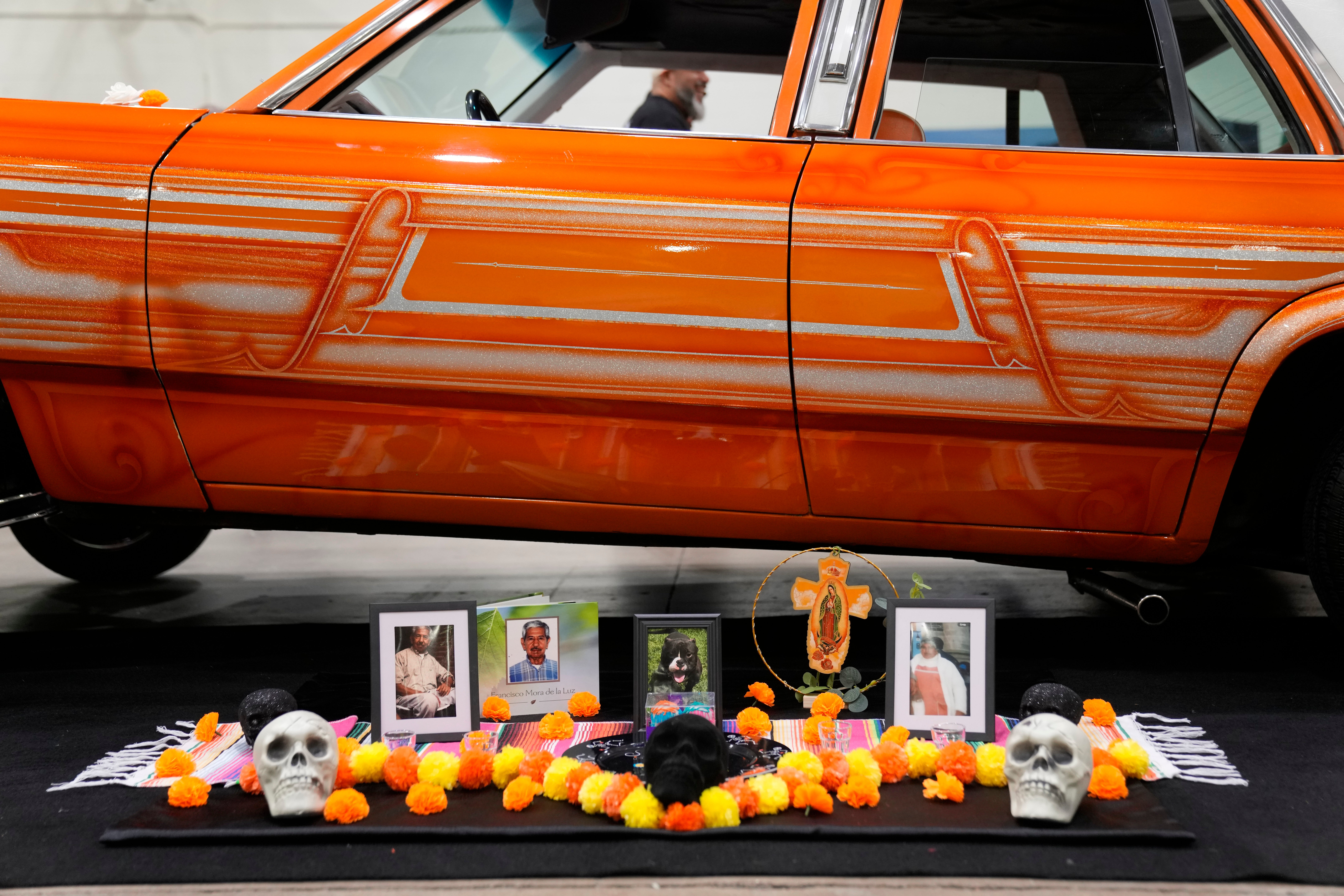 A Day of the Dead altar is placed next to a lowrider car on display at the Slow & Low Chicago Lowrider Festival