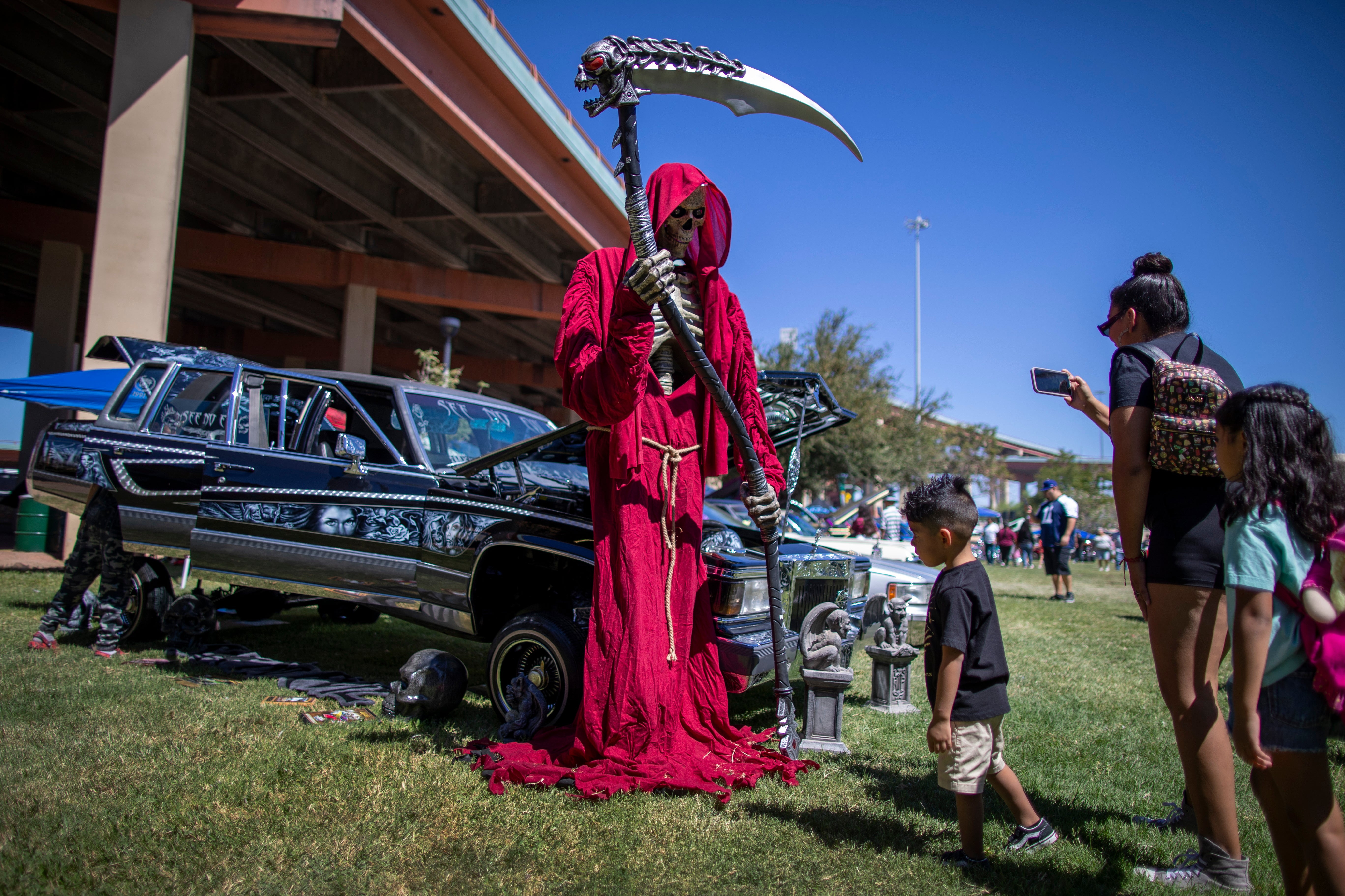 A family visits a vintage car during a lowrider exhibition for the 20th anniversary of Lincoln Park