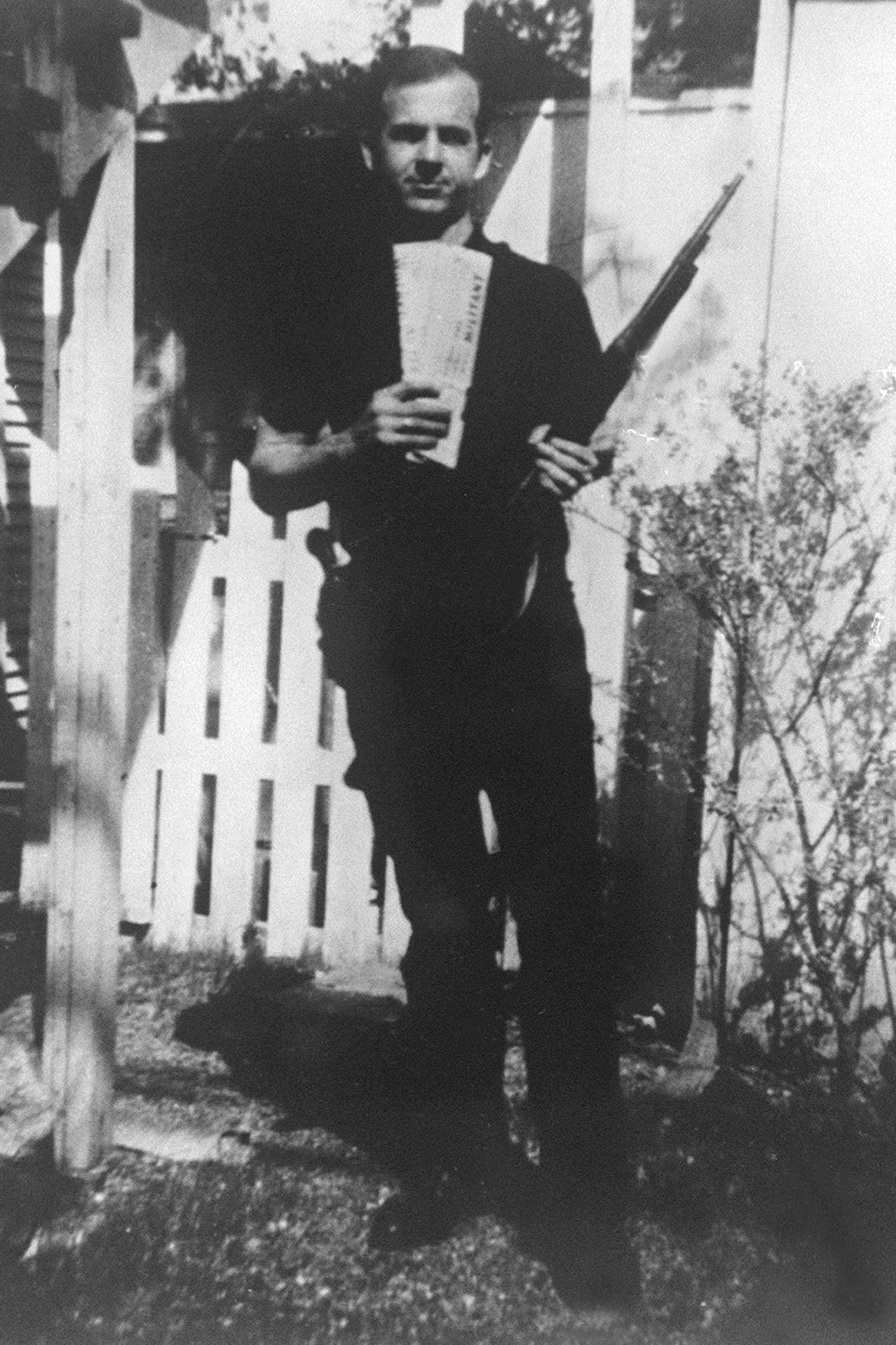 Harvey Oswald posing with a rifle in his garden