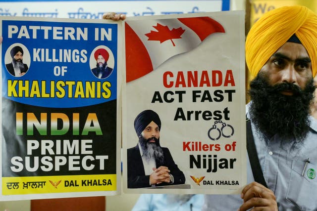 <p>A member of a Sikh organisation holds a placard displaying Sikh separatist Hardeep Singh Nijjar in Amritsar </p>