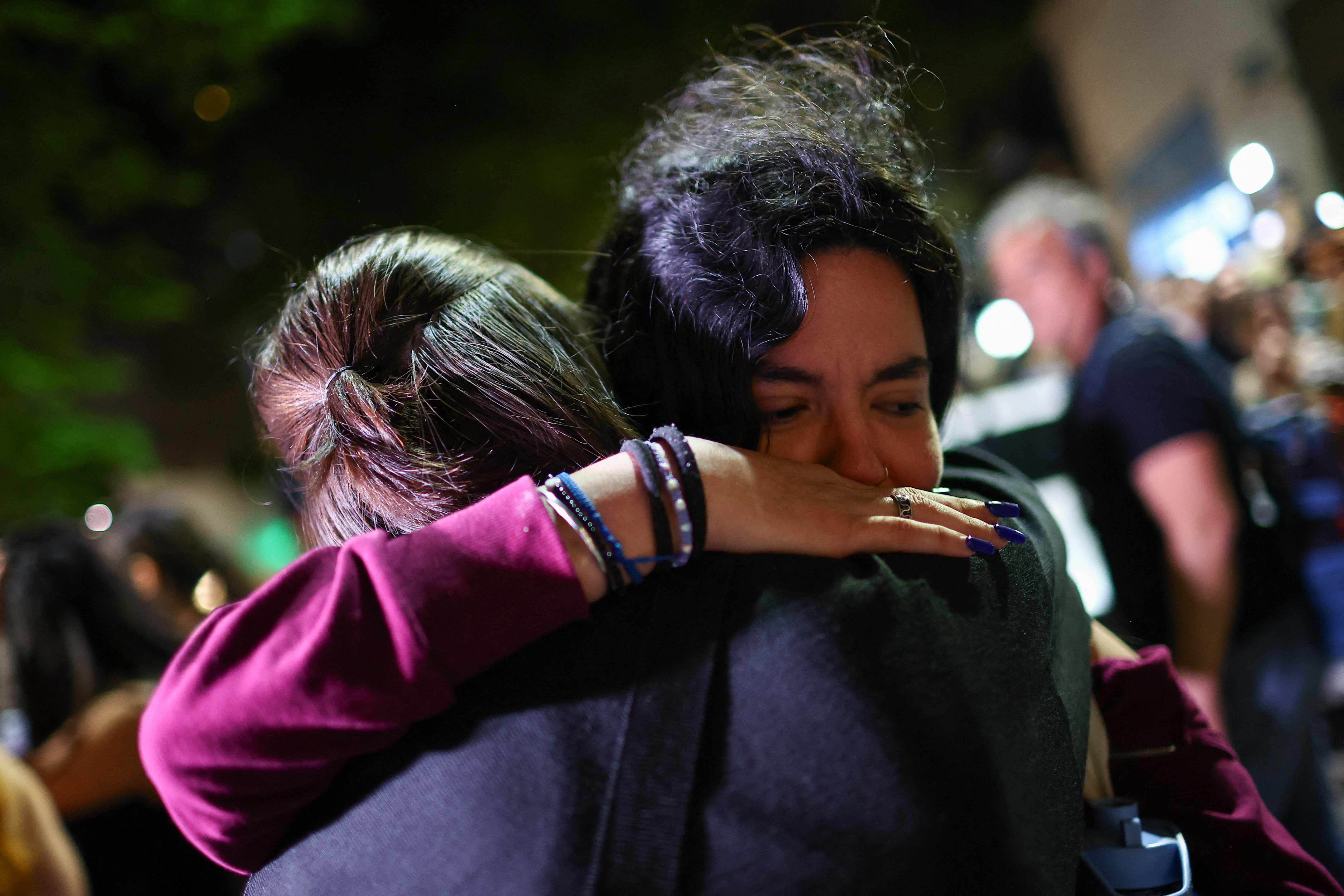 Fans hug outside the hotel where authorities found Payne’s body on Wednesday night