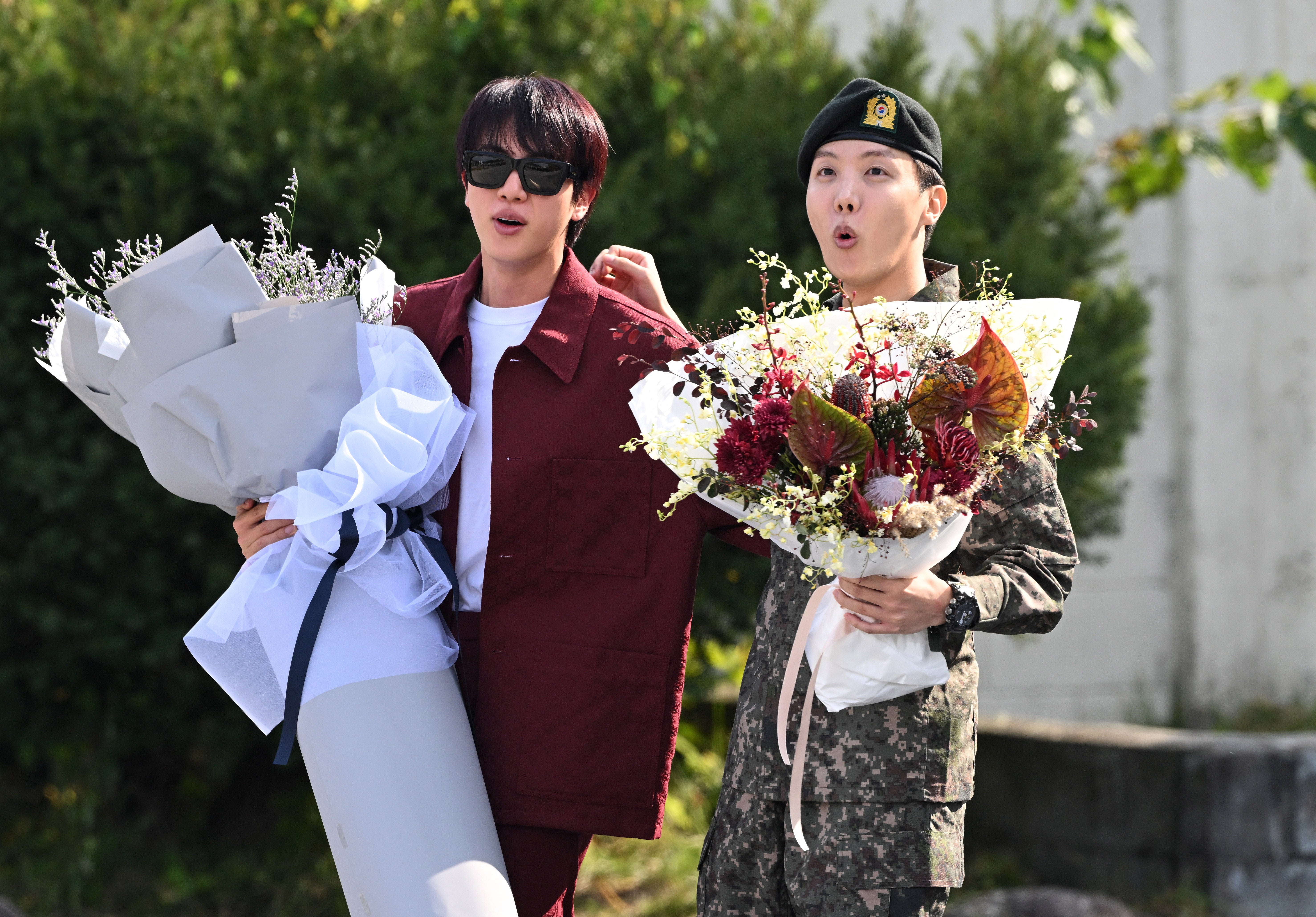 J-hope (right) is greeted by fellow member Jin after being discharged from his mandatory military service