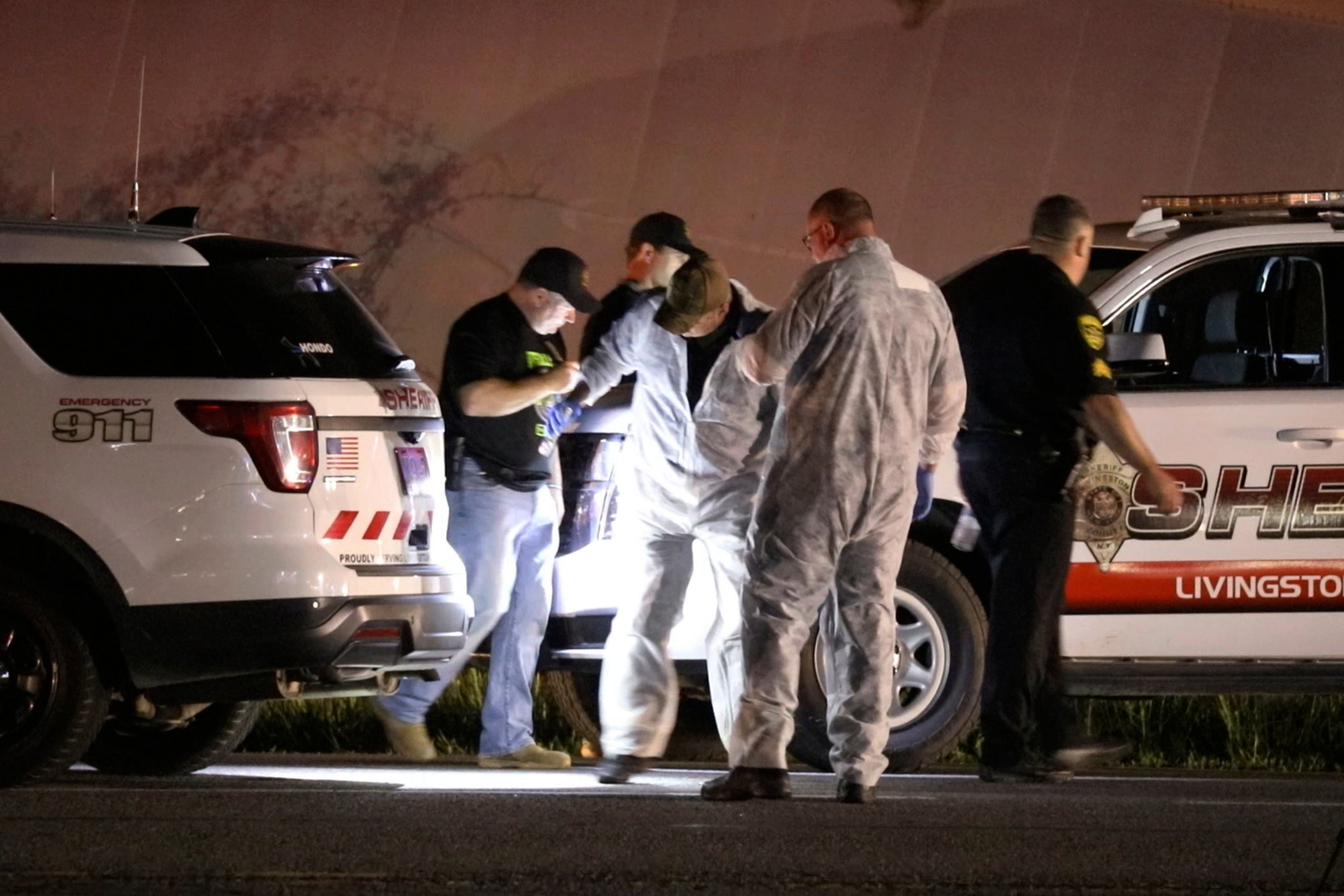 Livingston County Sheriff's deputies check their vehicles for bullet holes in Geneseo, N.Y., early Thursday, May 28, 2020, after a chase and shootout with Joshua Blessed