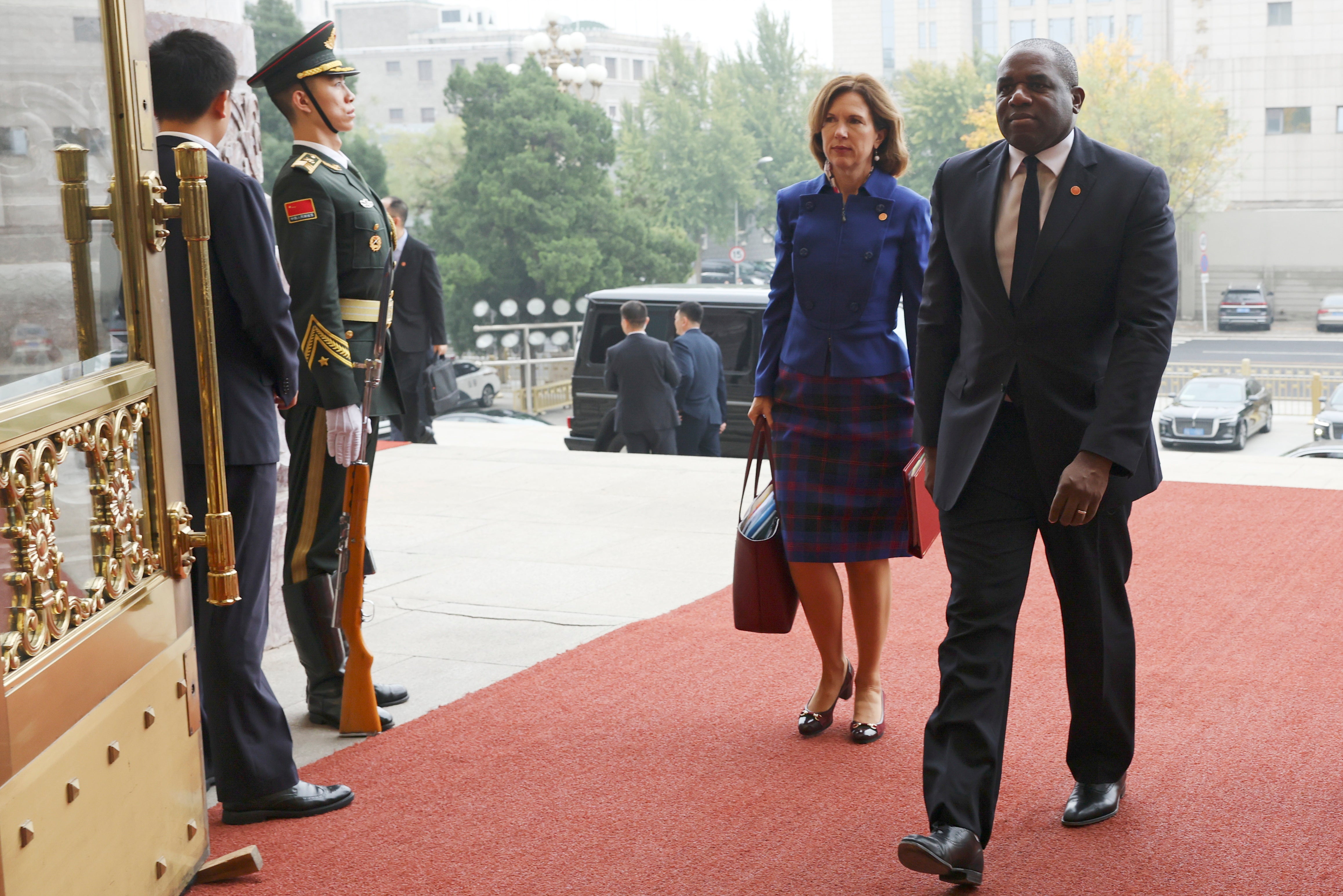 Britain's Foreign Secretary David Lammy (R) and British Ambassador to China Caroline Wilson (2-R) arrive at the Great Hall of the People in Beijing