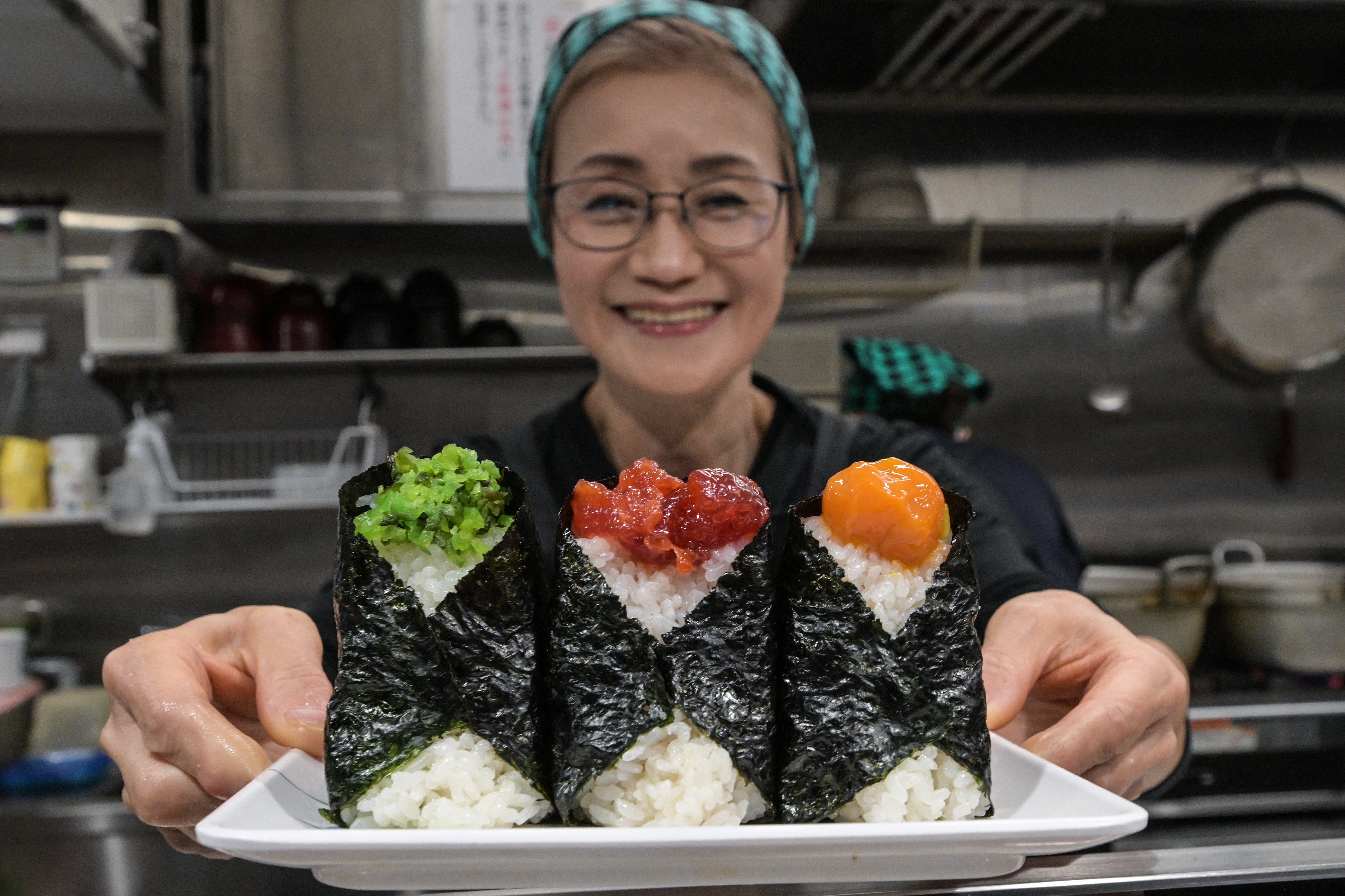 Yumiko Ukon poses with ‘onigiri’ she made at her Onigiri Bongo restaurant in Tokyo