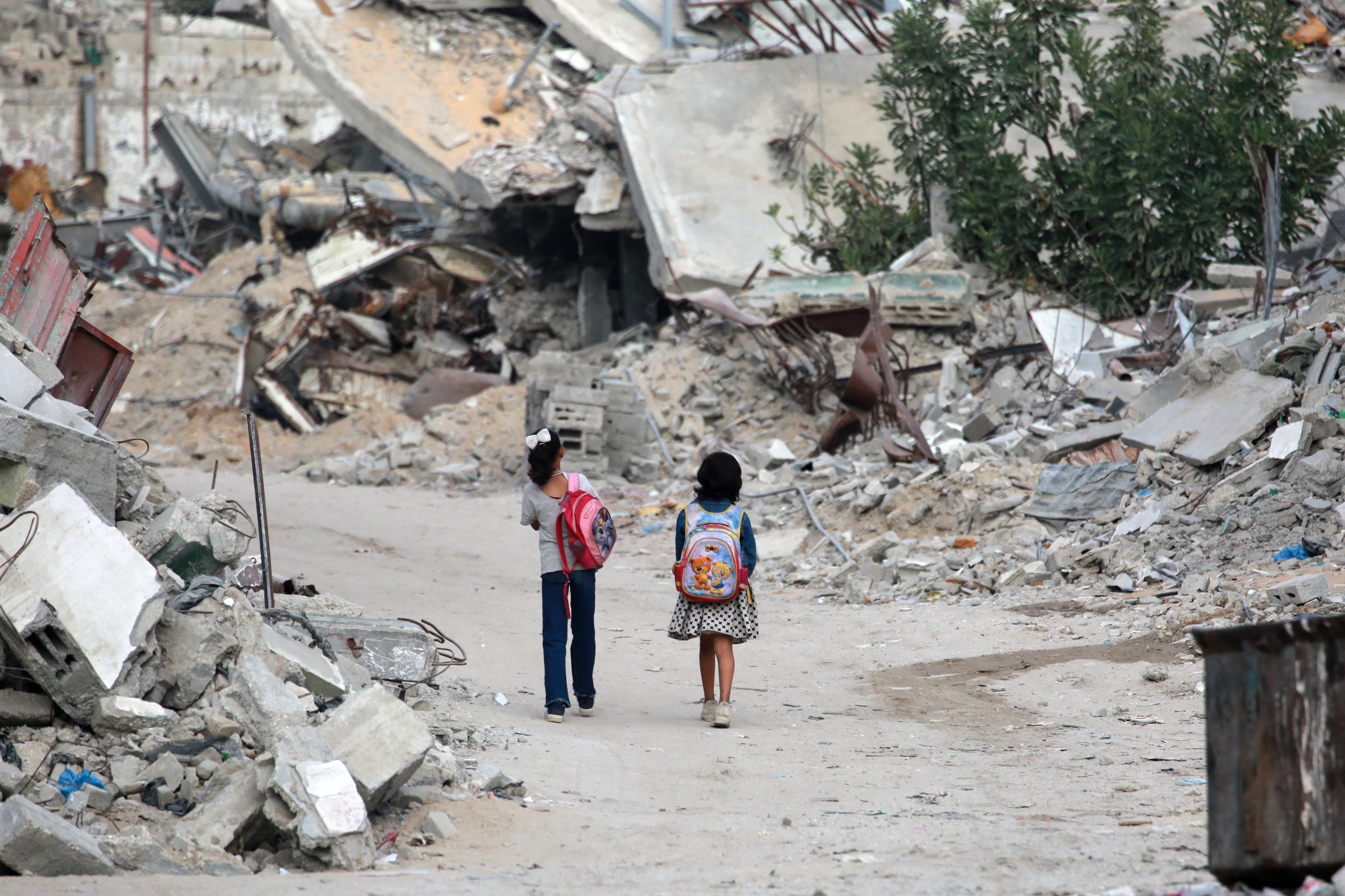 Girls walk past destroyed buildings in Khan Younis in the southern Gaza Strip this week