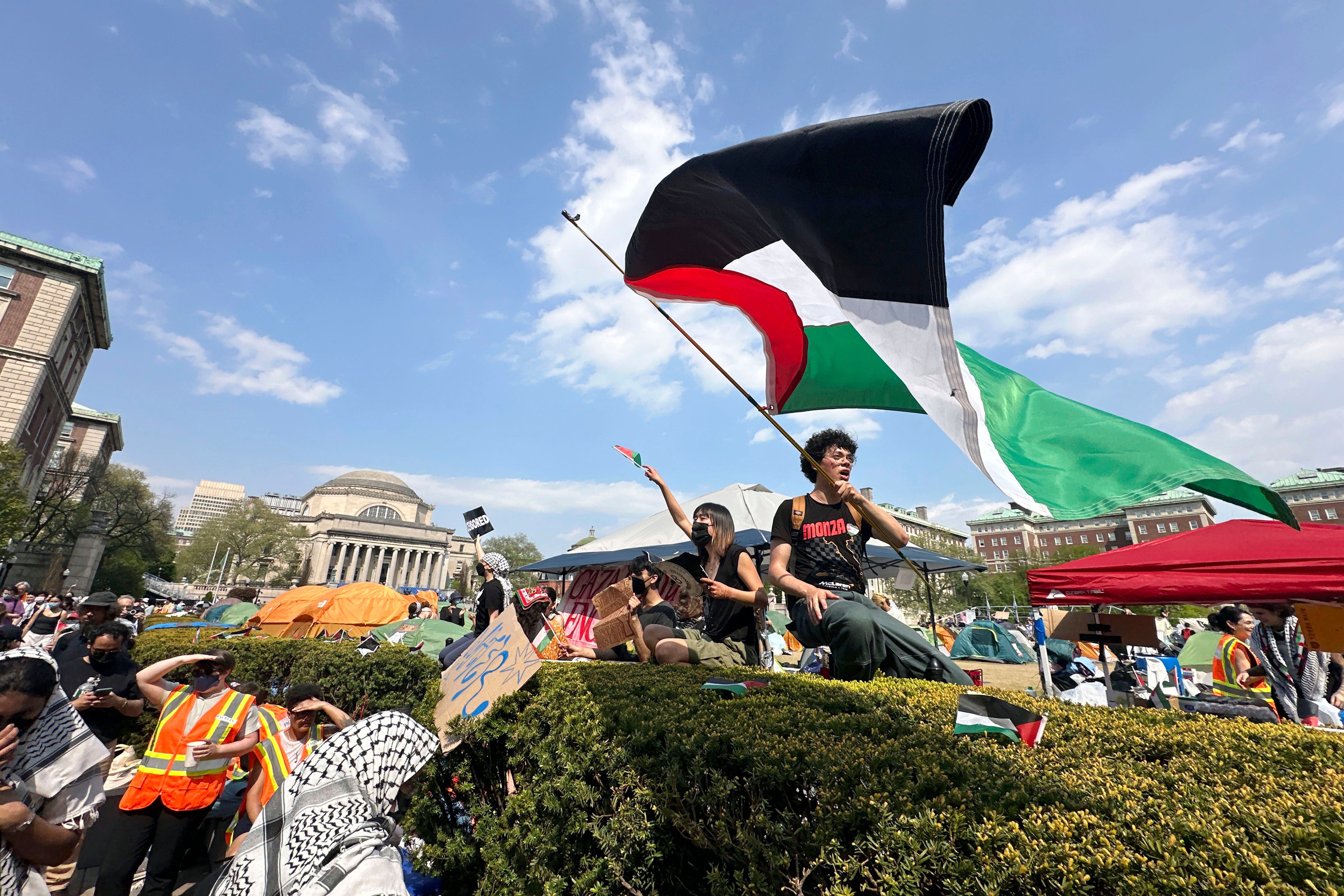 A demonstrator waves a flag on the Columbia University campus at a pro-Palestinian protest encampment