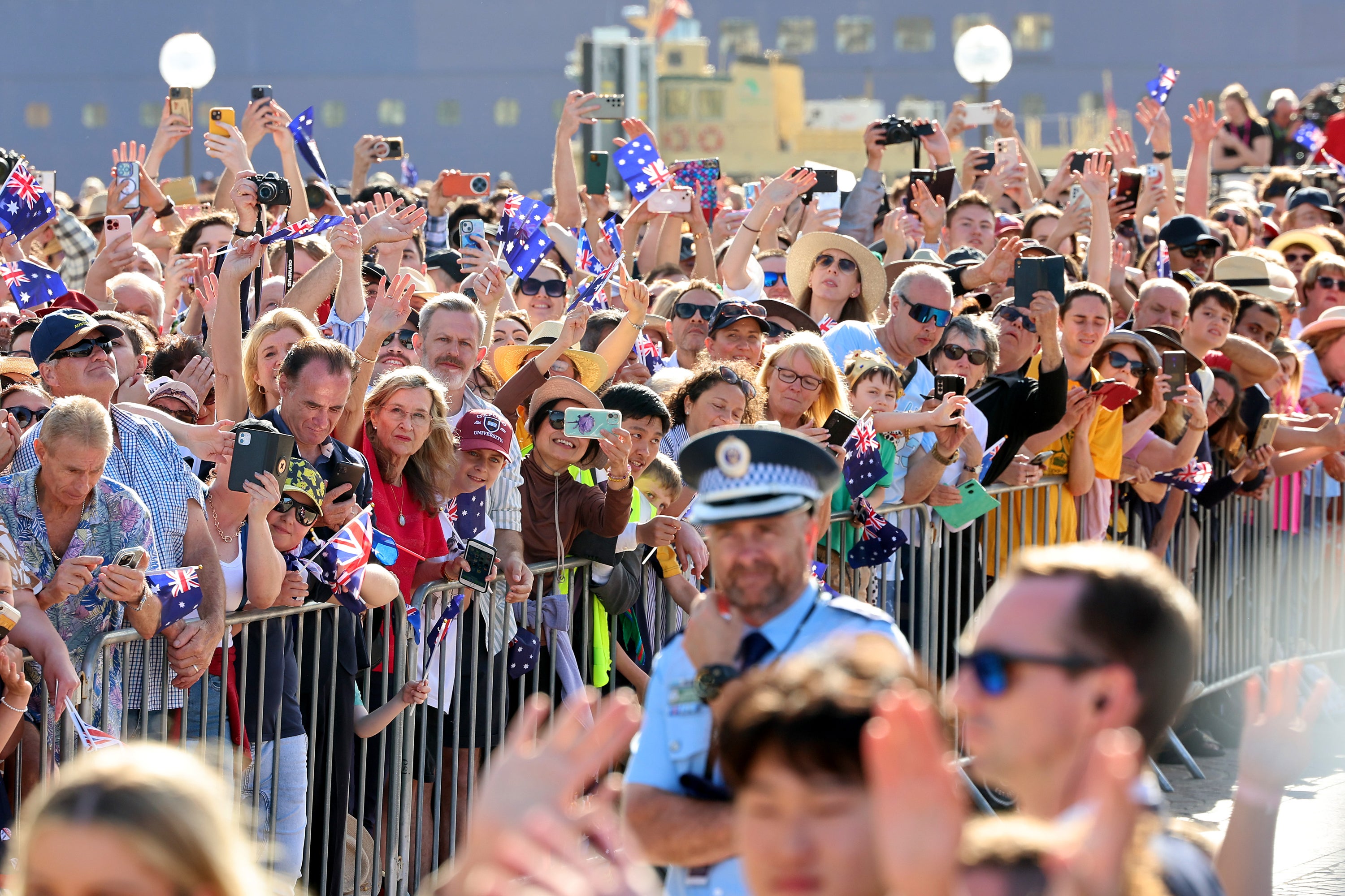 People line the forecourt at the Sydney Opera House as they await the arrival of King Charles III and Queen Camilla.